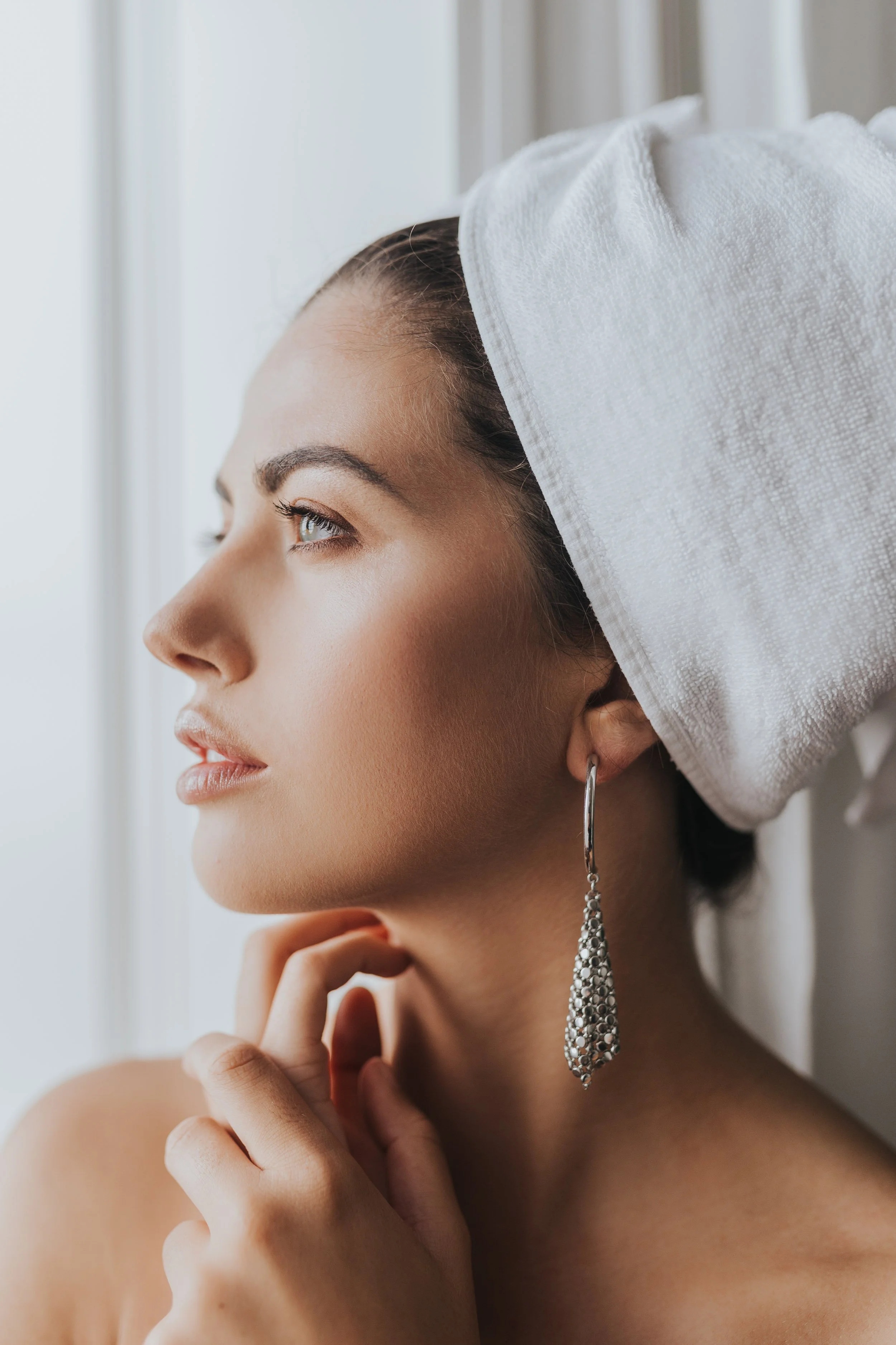 Model wearing an earring and a towel
