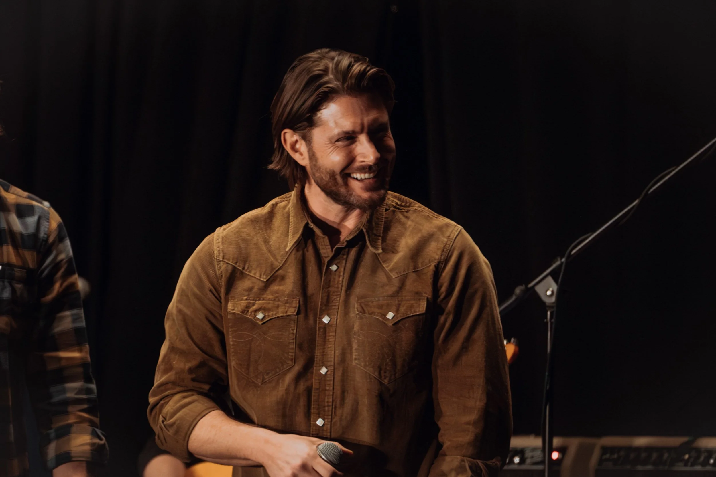 Jensen Ackles smiling in a con