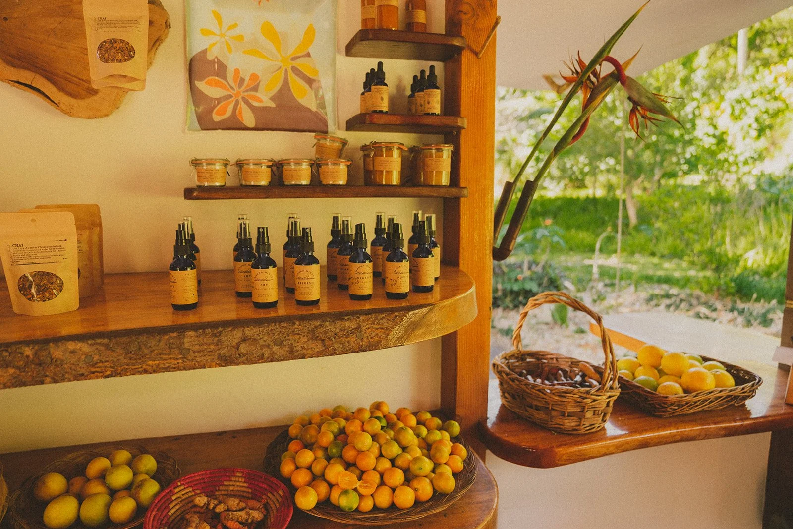 Rustic shop shelves with bottles, jars, and baskets of fruit.
