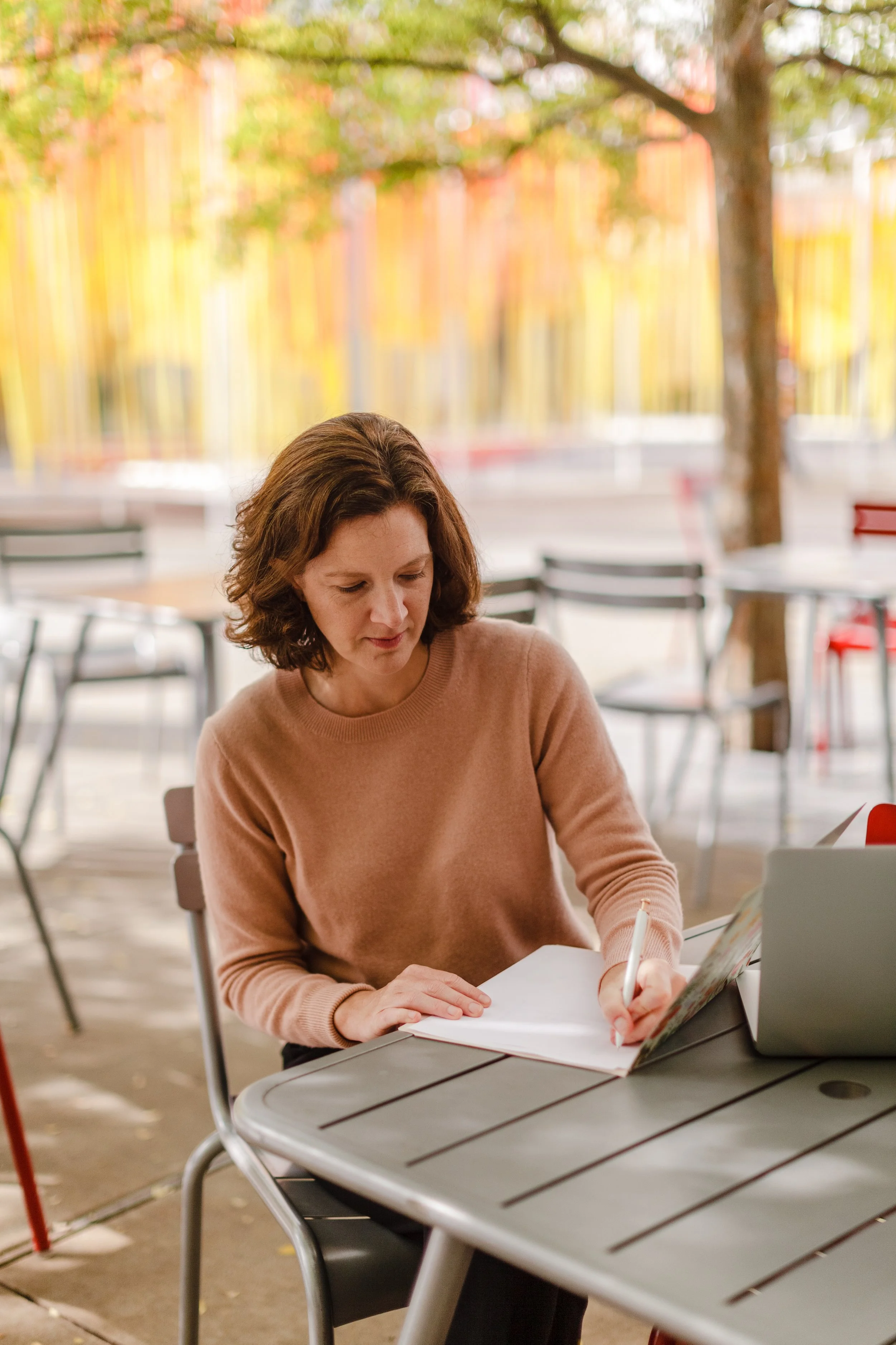 Kate Christman sitting outside under tree with computer | Therapy for Families