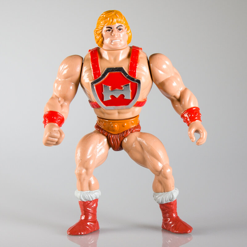  This version of He-Man has a redesigned torso to accommodate the action feature and a hard head. 