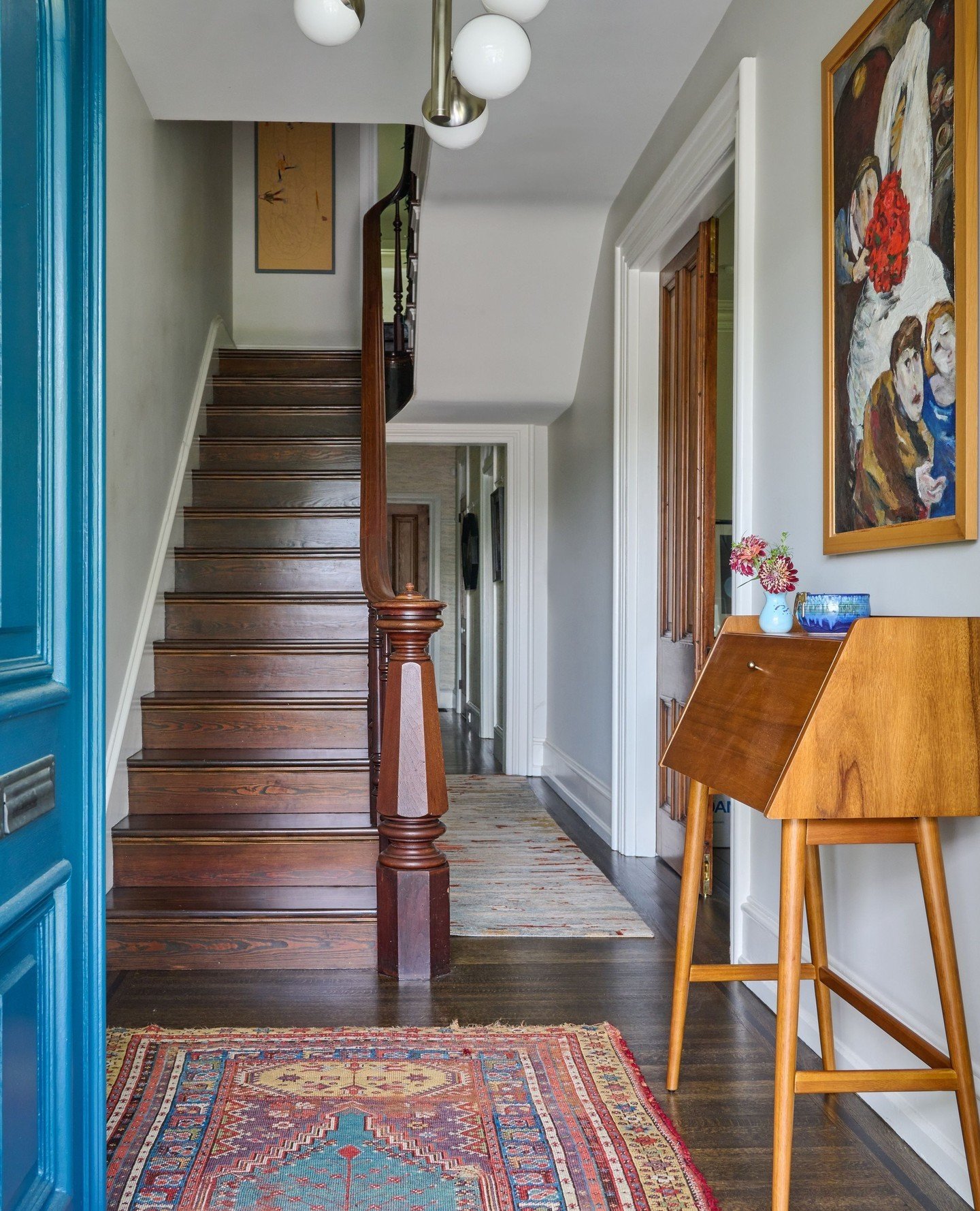 The perfect harmony of cultures and eras! This stunning Austrian painting takes center stage in the foyer entry, beautifully complemented by a richly textured Turkish rug and the timeless elegance of a Victorian staircase (that newel post though!). E