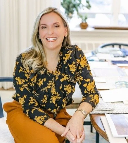 Interior designer Georgia Zikas, founder of Georgia Zikas Design, seated at a design workspace and smiling during a professional portrait featured in the Tile America designer interview.