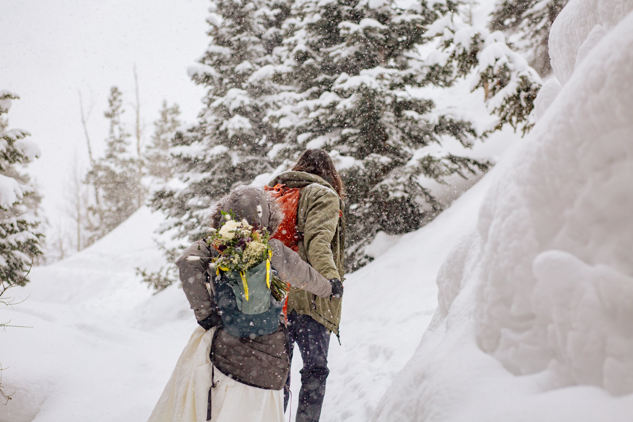  Couple hikes with their gear while in their wedding attire for their Rocky Mountain National Park elopement. 