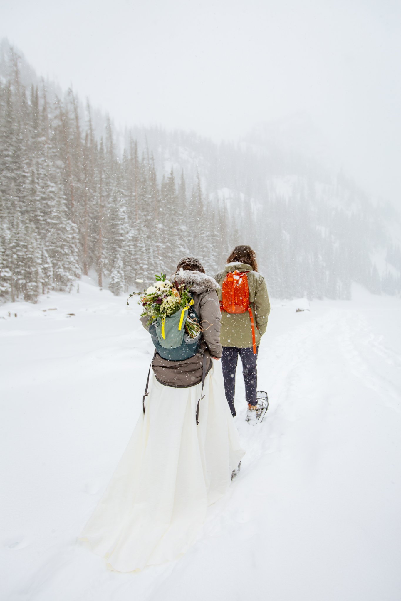  Couple hikes with their gear while in their wedding attire for their Rocky Mountain National Park elopement. 