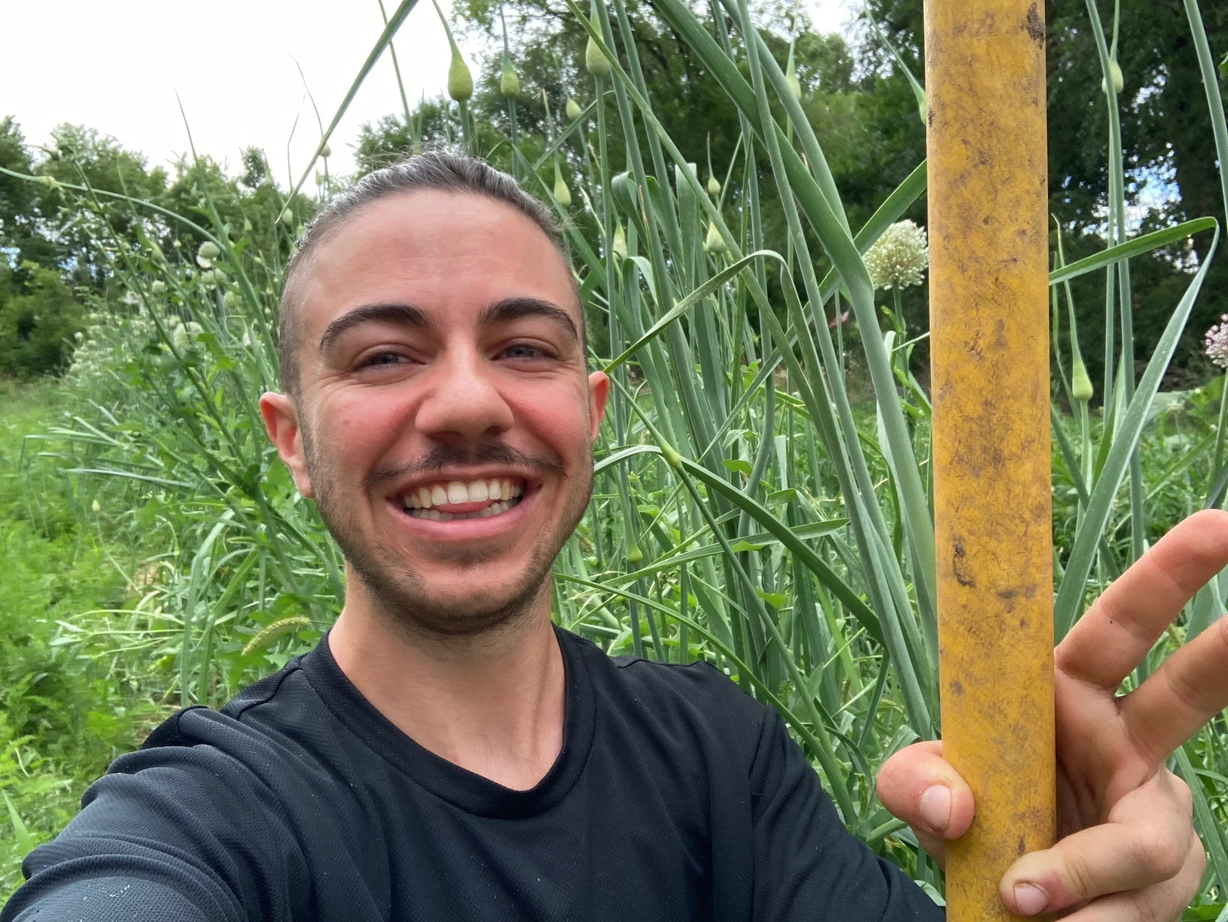 Young man smiling outdoors in a garden