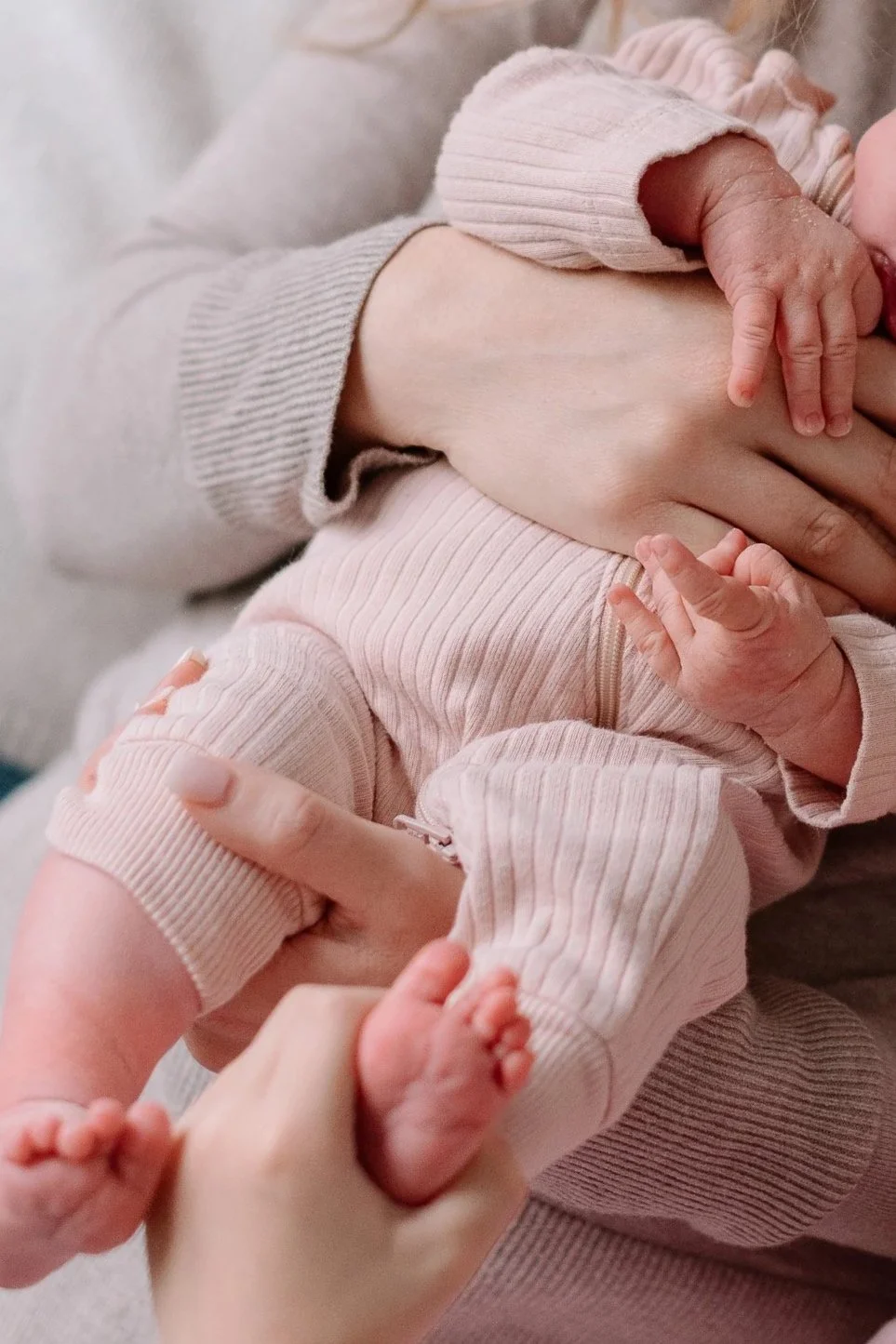 Parents and son embrace a newborn girl with full head of hair to celebrate her birth
