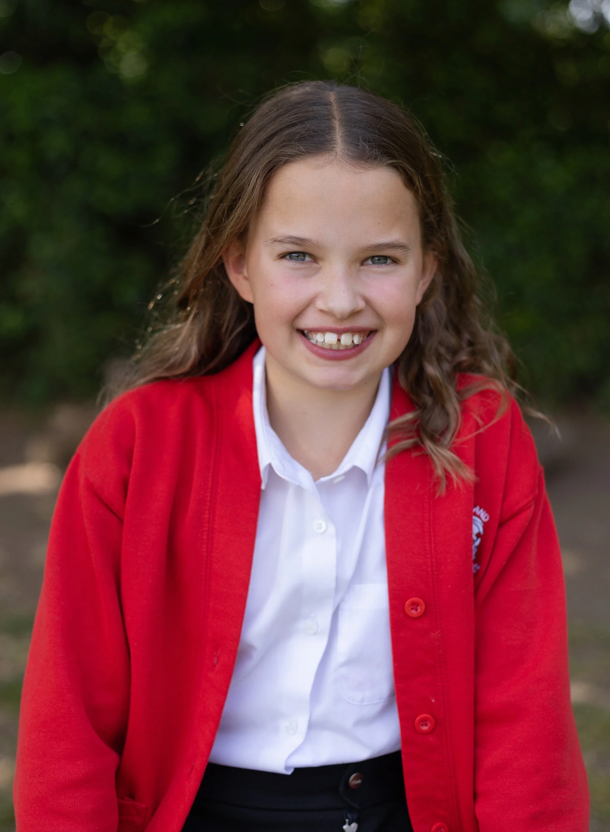 Girl sat outside for outdoor school pictures. West Berkshire outdoor school pictures