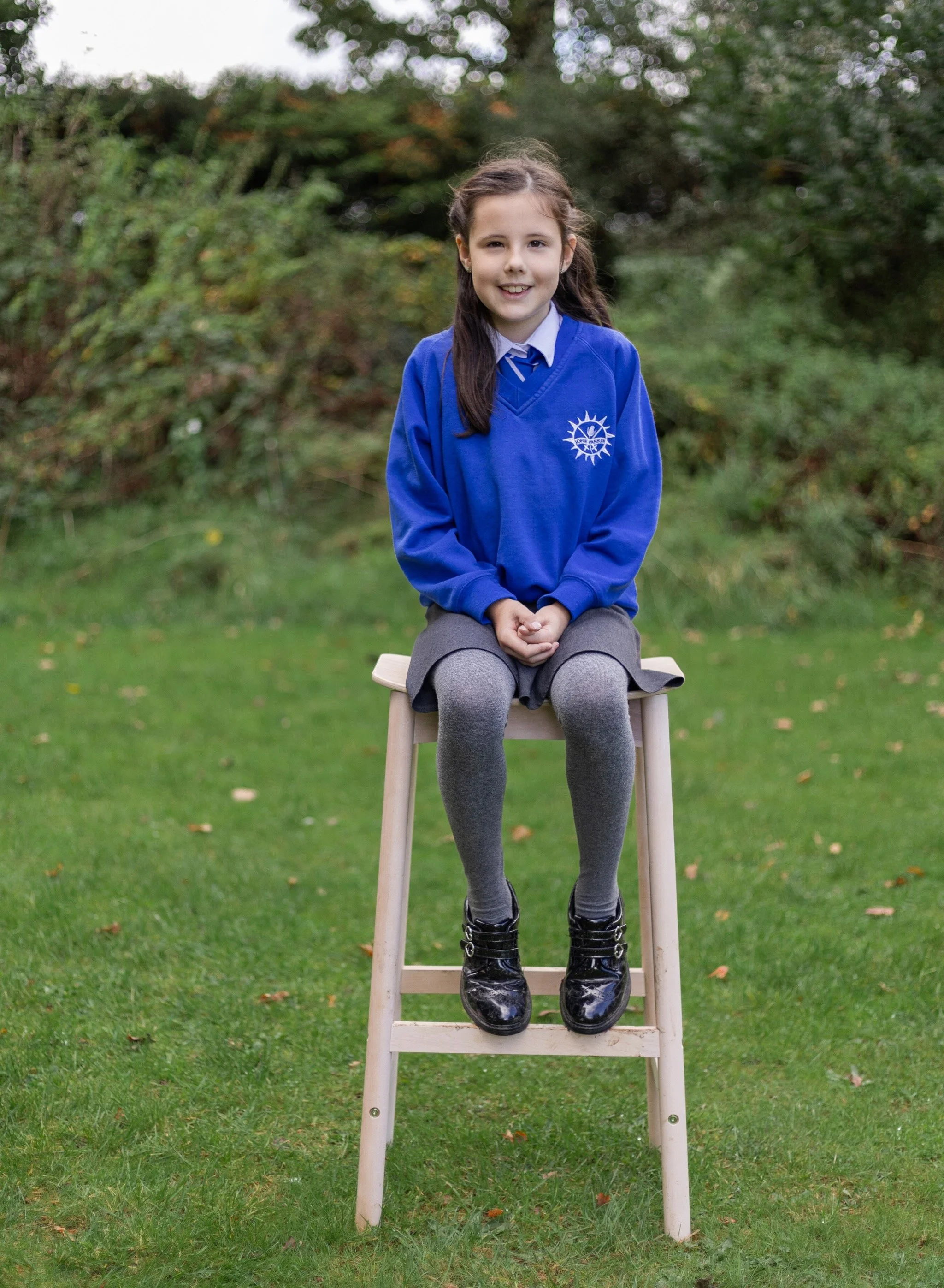Girl sitting on bench for outdoor school pictures, outdoor school pictures west berkshire