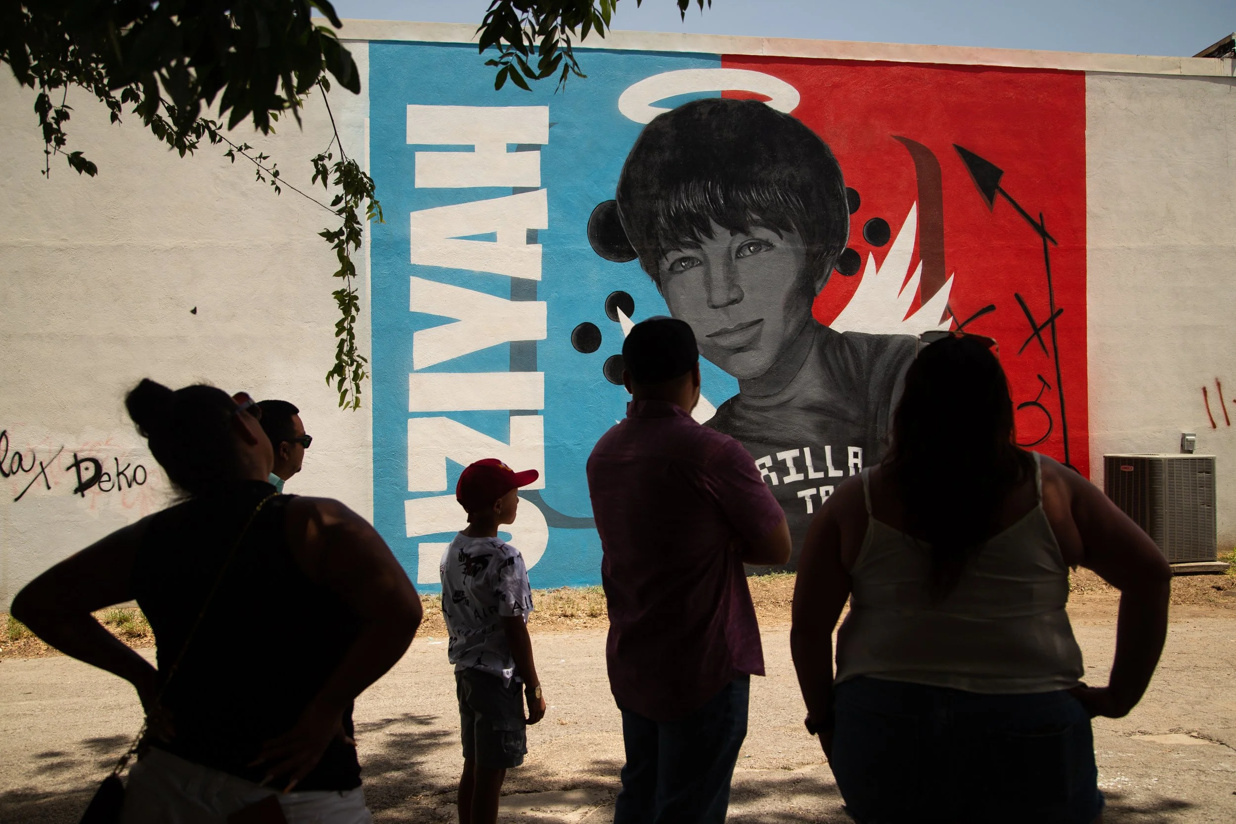 Family members and friends of Uziyah Garcia view a freshly completed mural in his memory in Uvalde on July 17, 2022. Each of the 21 victims of the Robb Elementary shooting will receive a mural painted by artists from across Texas.   