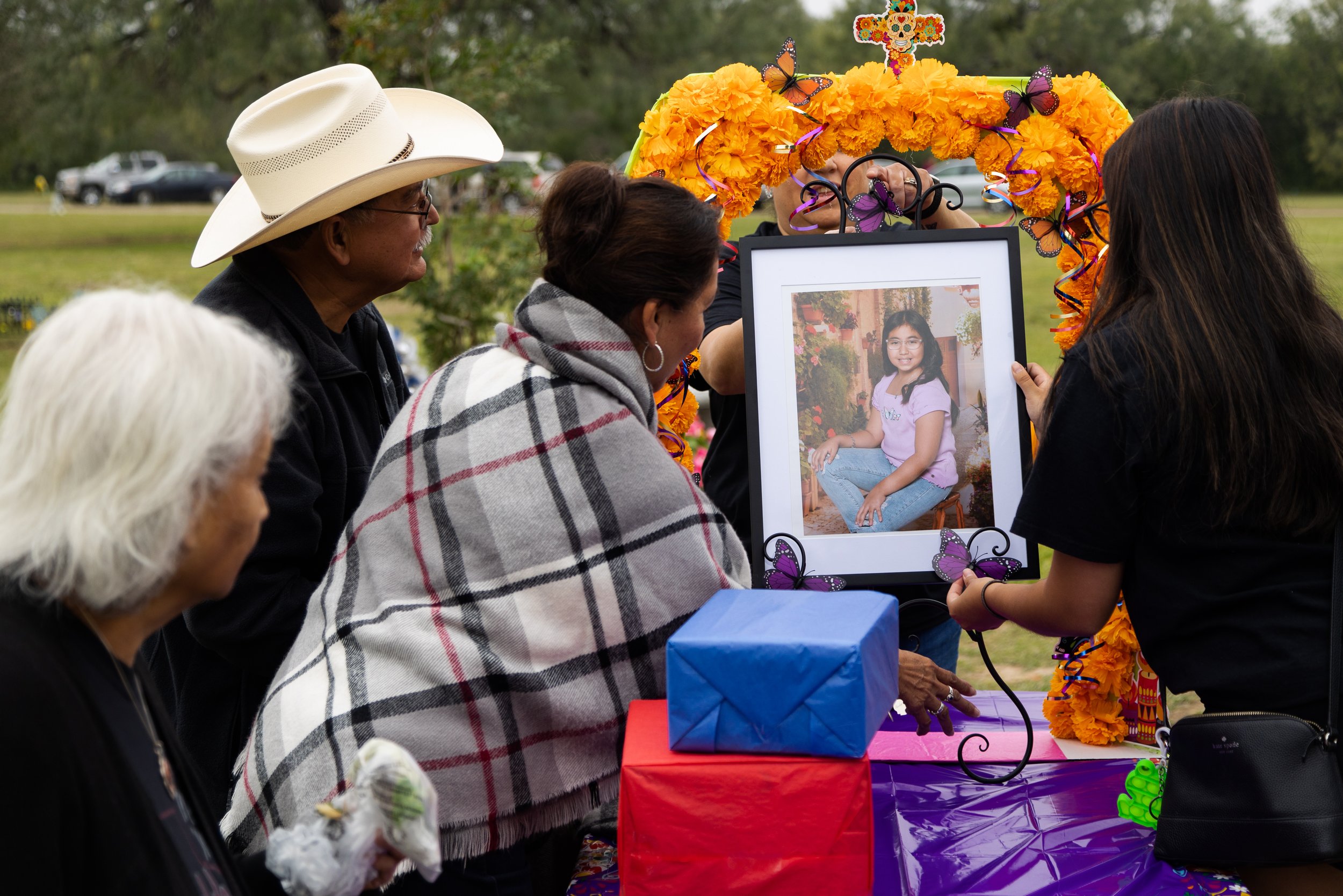  Faith Mata, right, places a portrait of her younger sister, Tess, onto an ofrenda for her before Dia de los Muertos celebrations in the Hillcrest Memorial Cemetery in Uvalde on Nov. 2, 2022. 