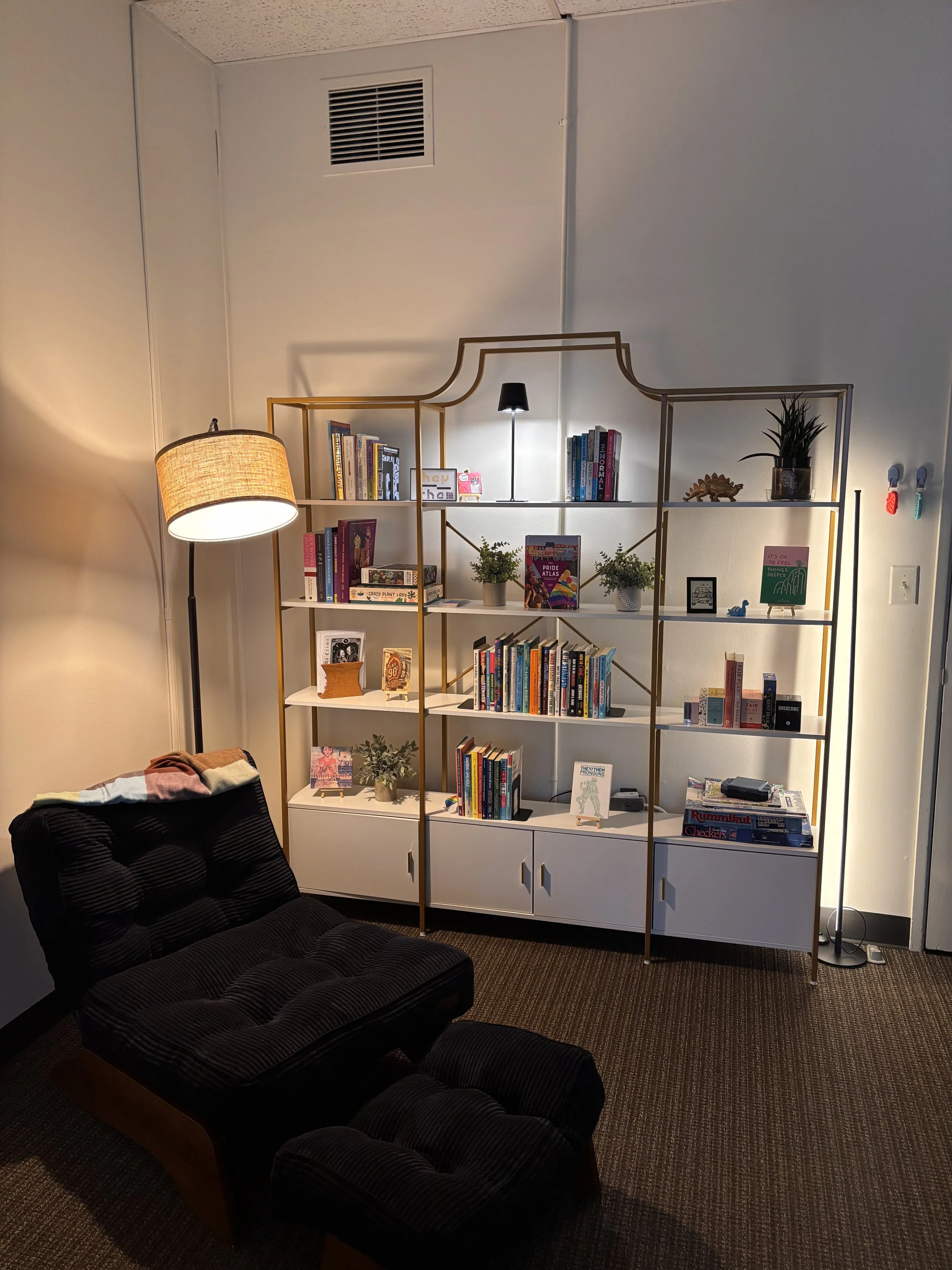 Photo of a bookshelf in the Perfectly Queer Counseling lobby