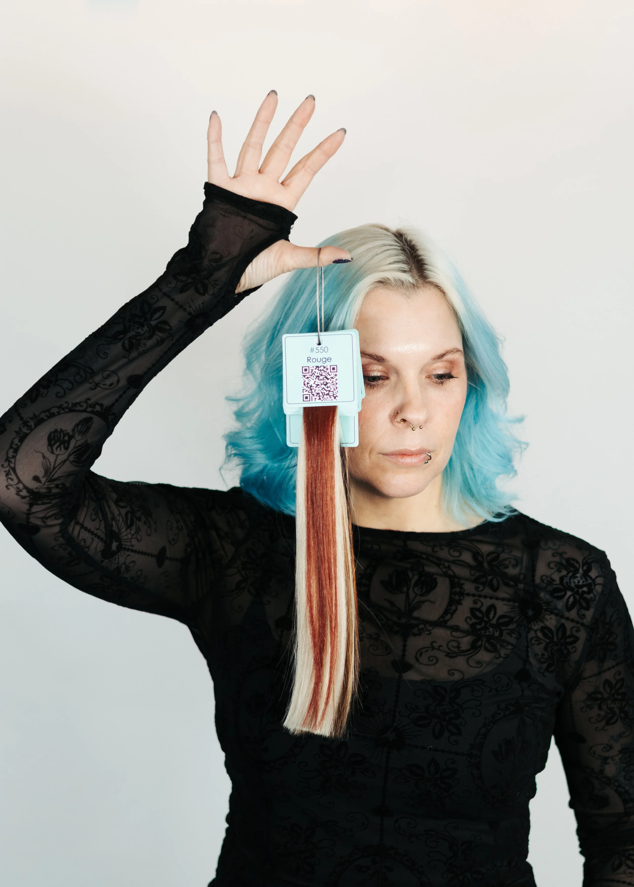 Anchorage Hair Extensions Specialist Holding custom colored hair for color matching Hair extensions.
