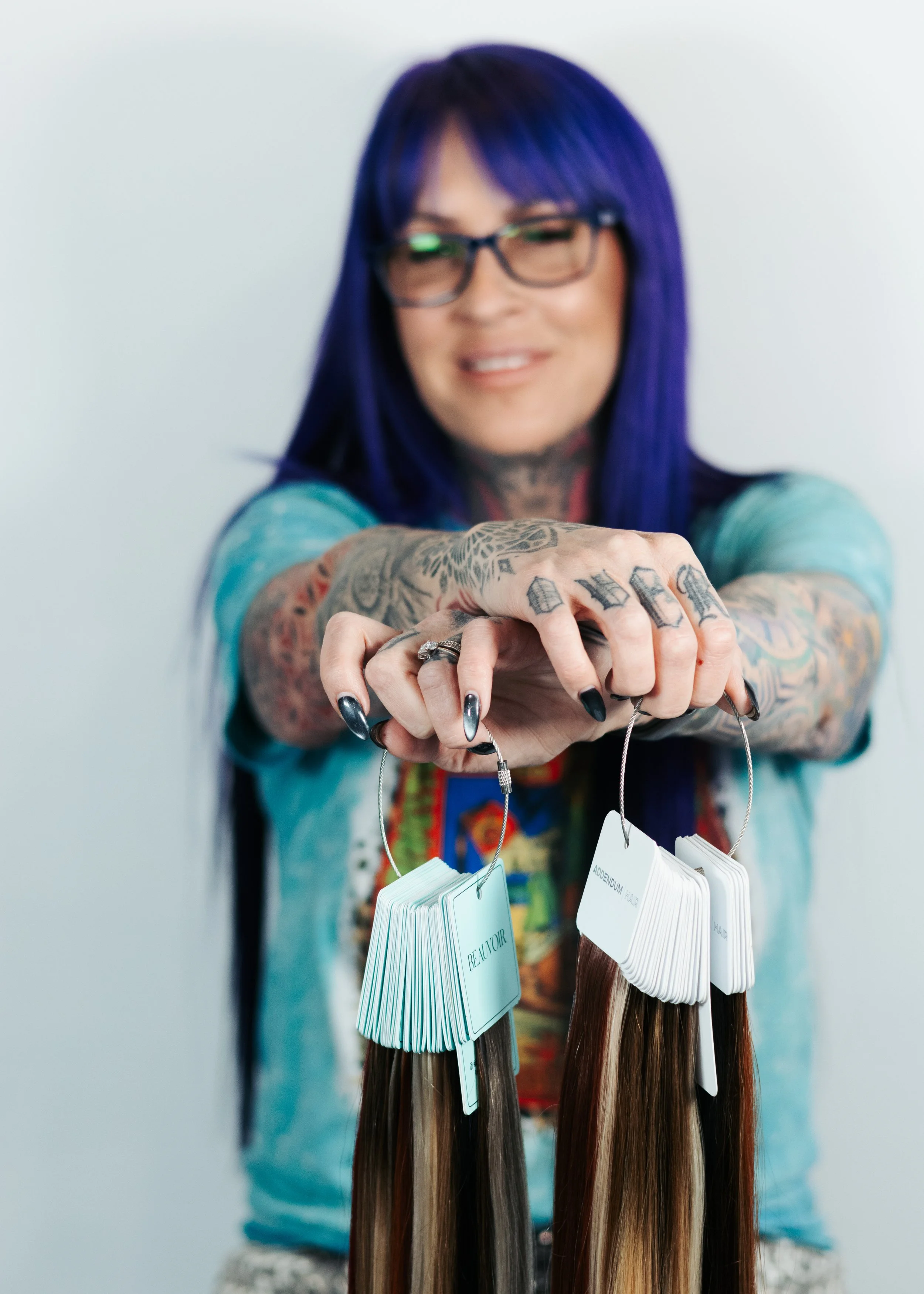Tattooed Styled holding Hair Extensions for color matching  at Misfits Salon Alaska.