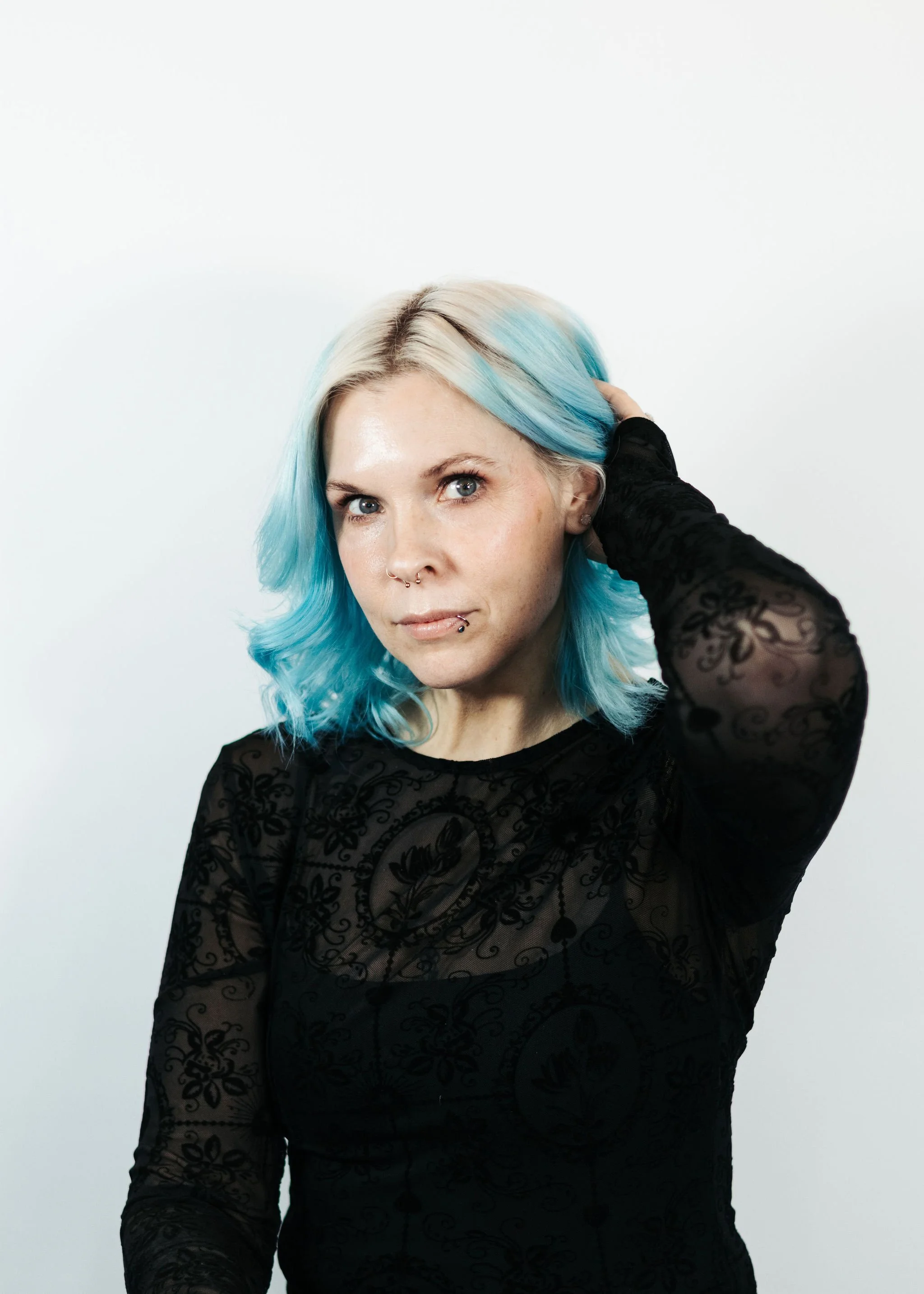 Anchorage Stylist with Blue Hair. She is wearing a black a black top and works at Anchorage Hair Salon in Alaska Called Misfits Salon.