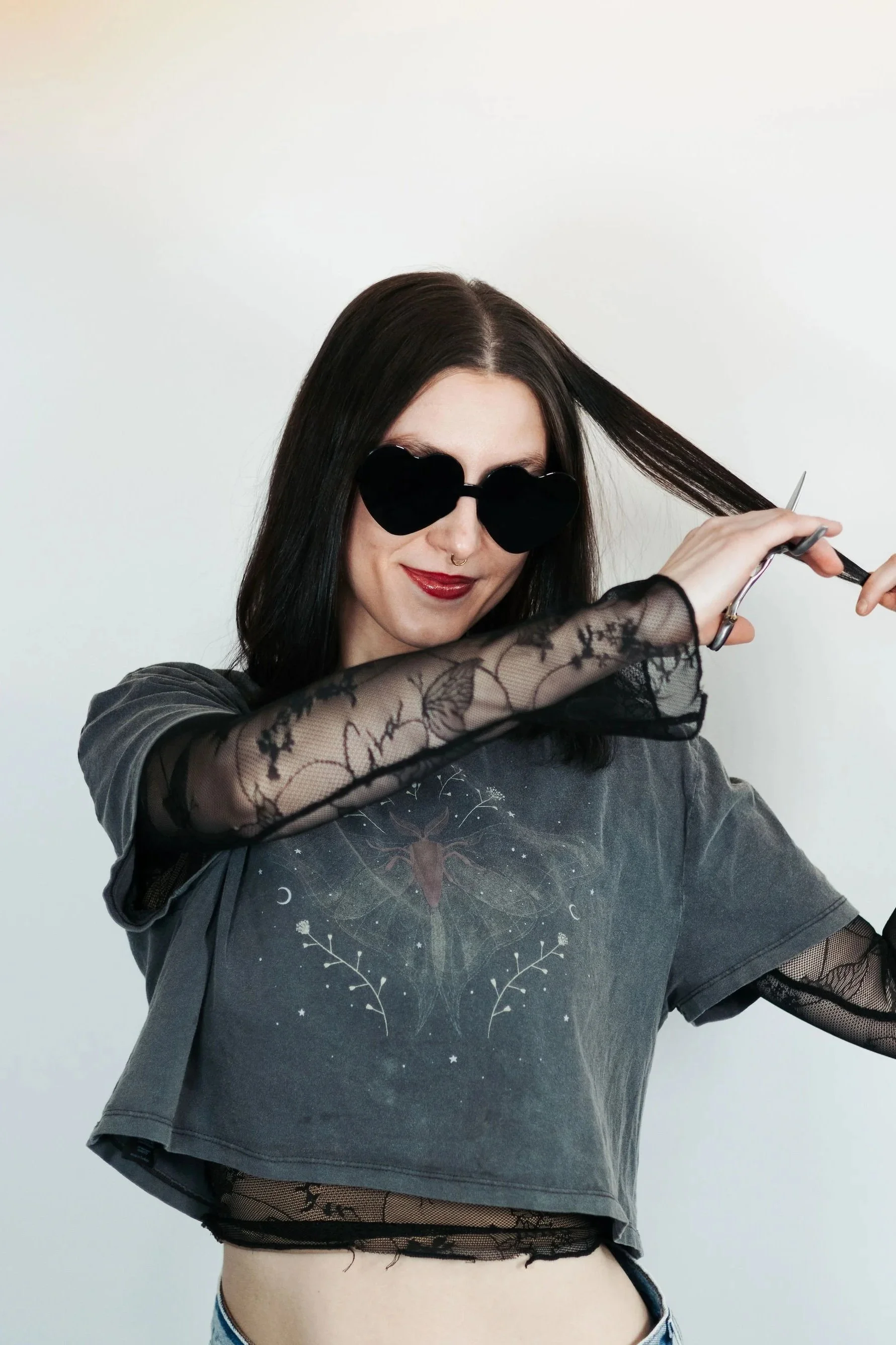 Anchorage Stylist Angel. She has shears pretending to cut her hair for the photo, She specializes in wolf cuts and alternative hair styles. Loves to do vivid hair color at Misfits Salon in Anchorage Alaska