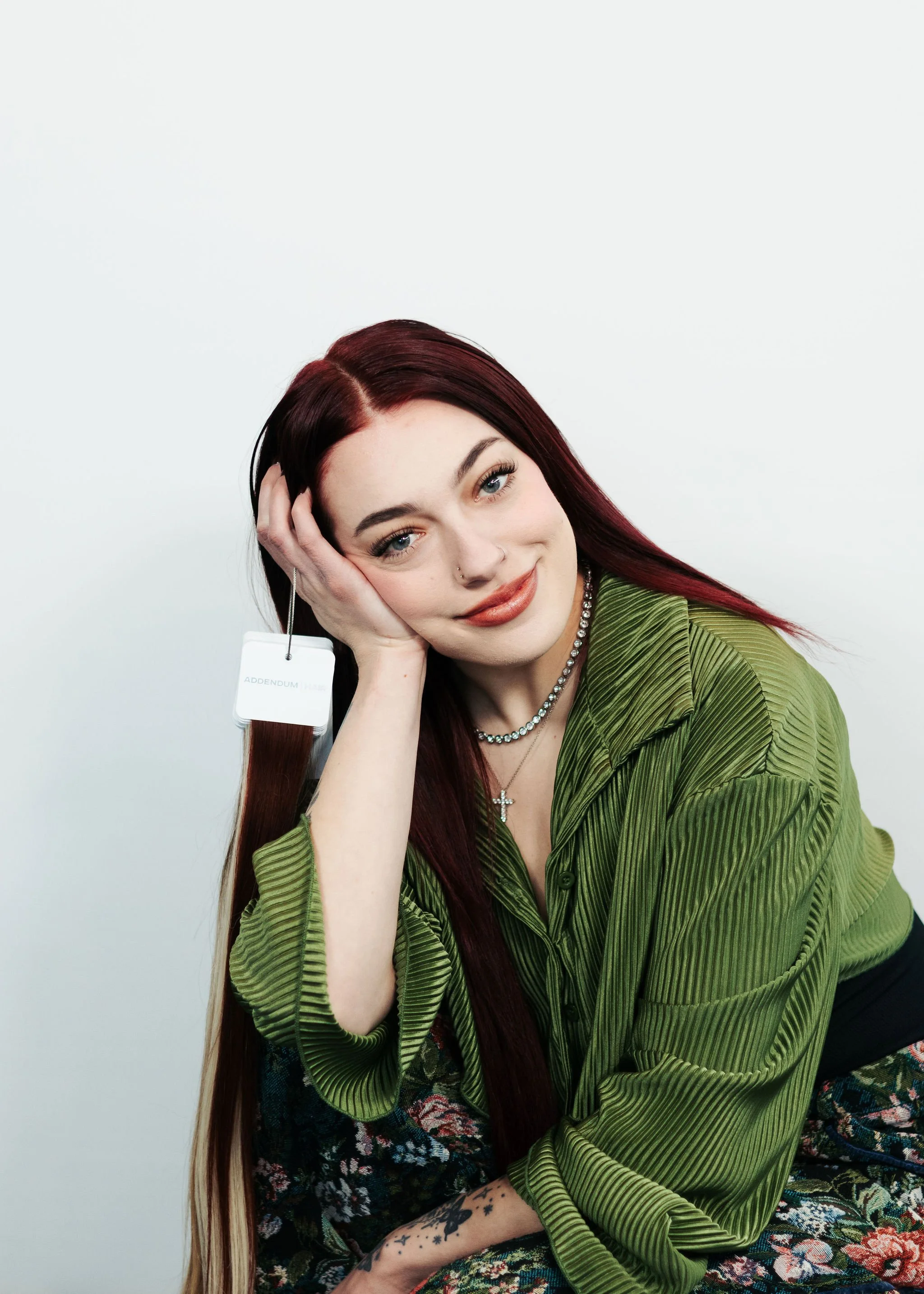 Anchorage Stylist Aubrie. She has red hair and is holding extensions.