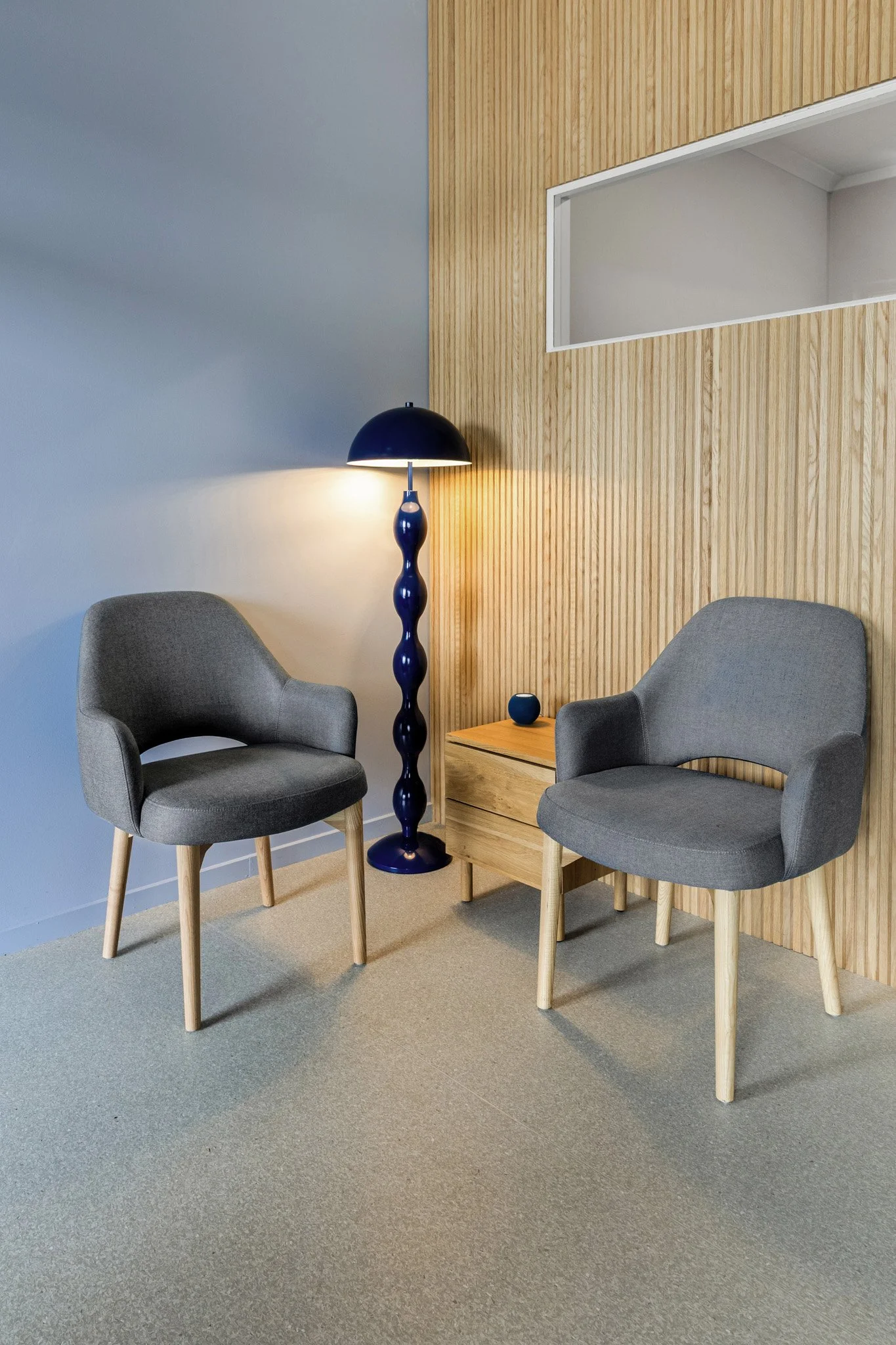 The reception's white oak scalloped wall lining softens the entry and creates a warm first impression