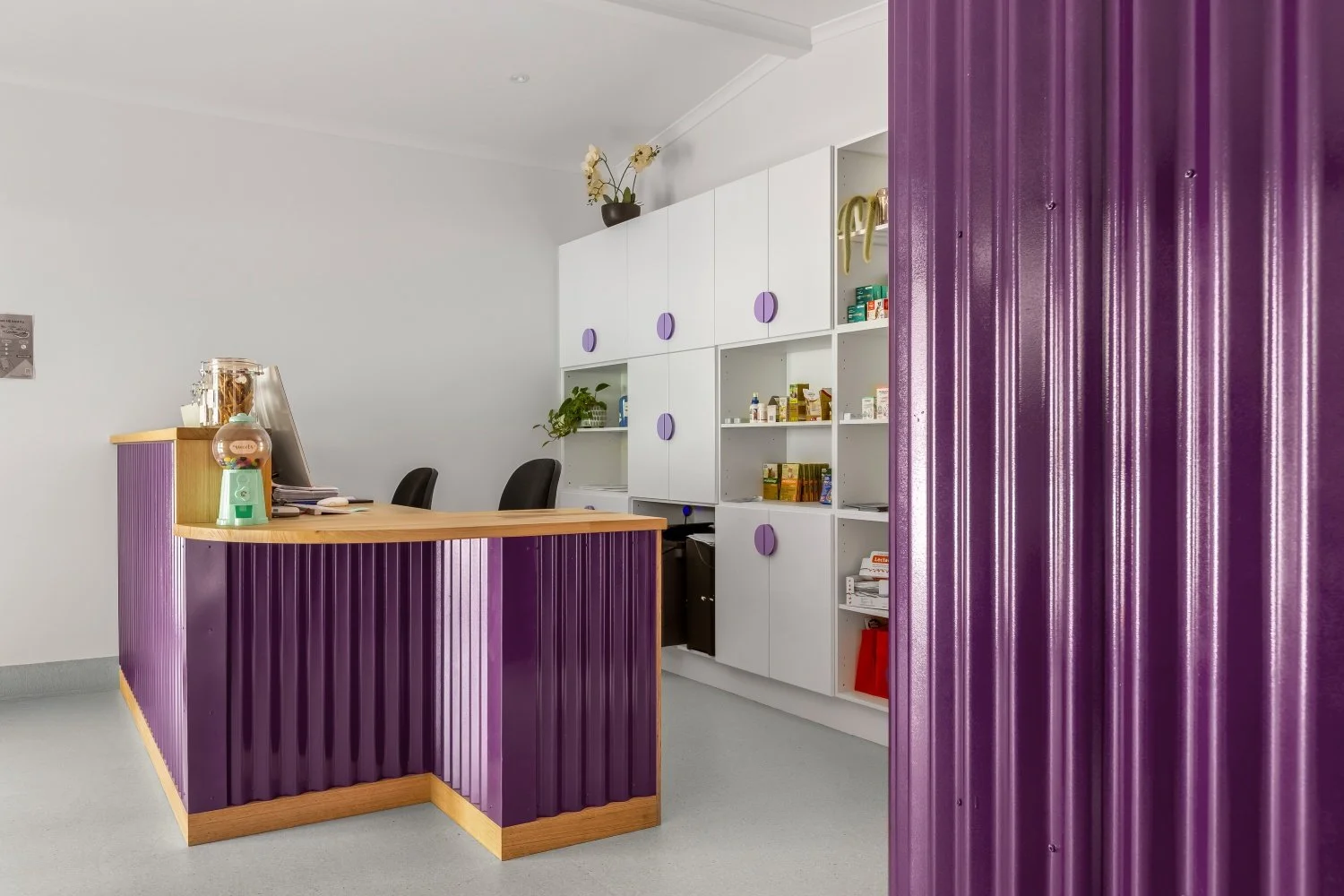 Custom veterinary reception desk with purple corrugated iron and natural timber countertop