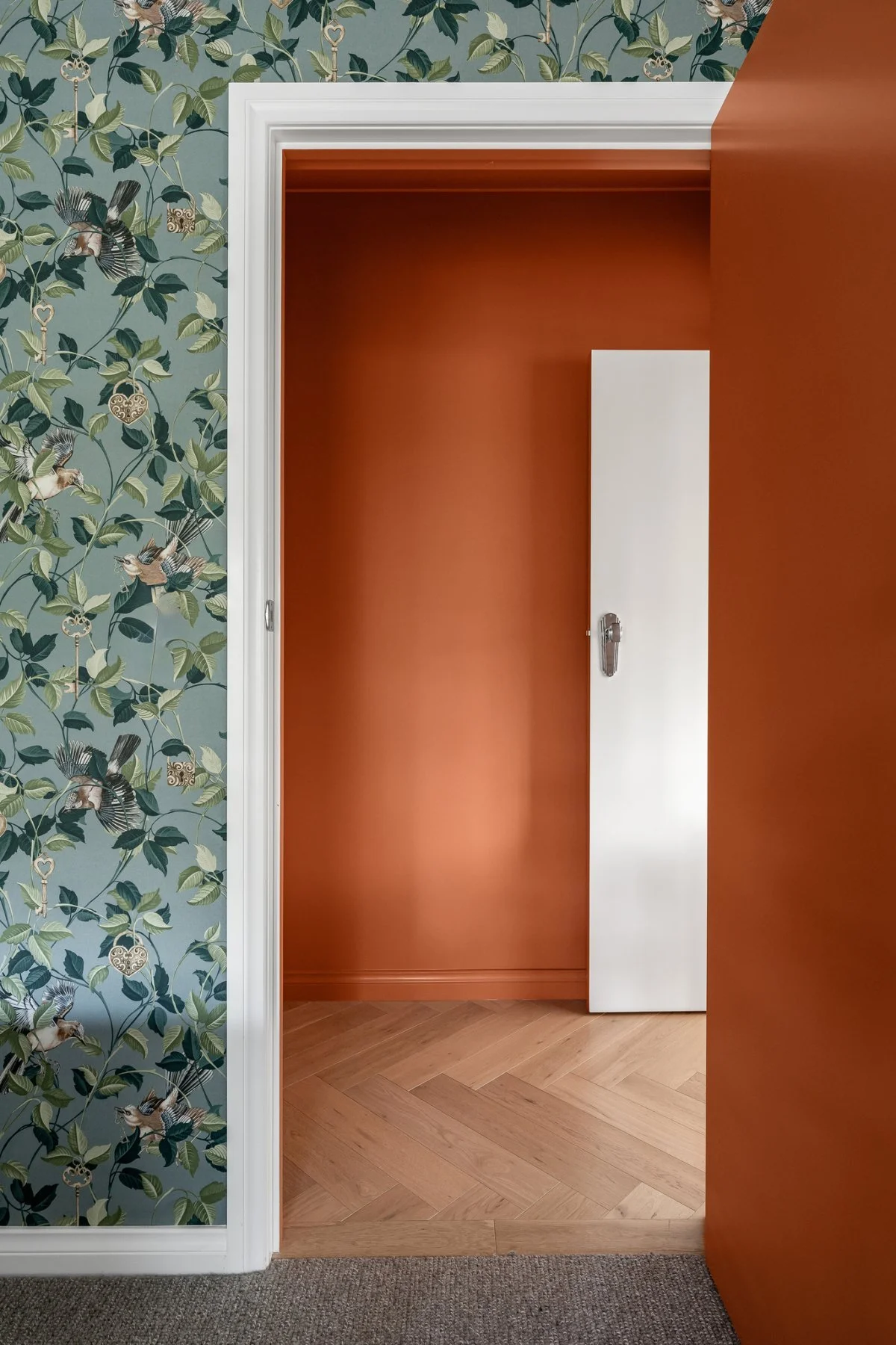 Botanical wallpaper in the bedrooms sits adjacent to the atmospheric threshold of the hallway.