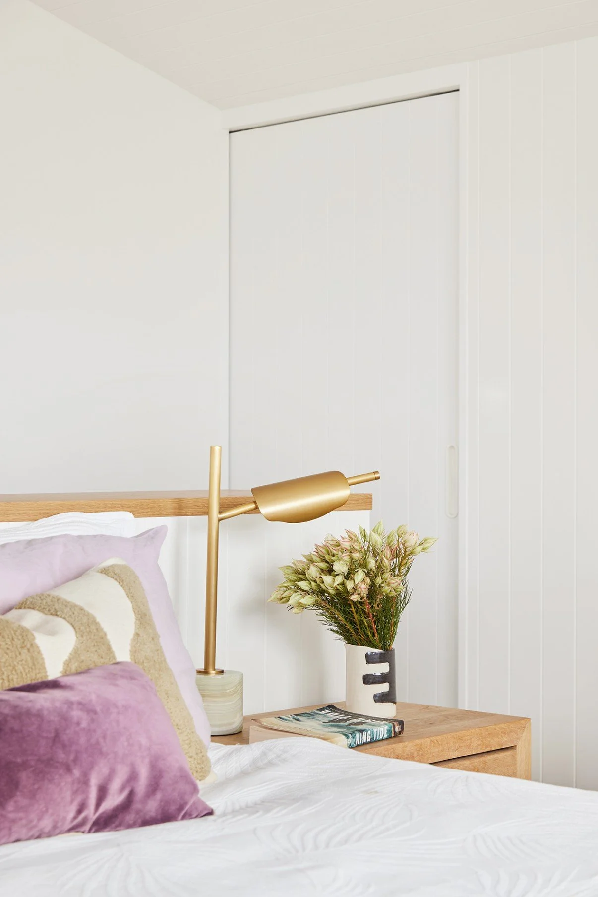 Main suite bed with walk in robe concealed behind at High Tide Freshwater