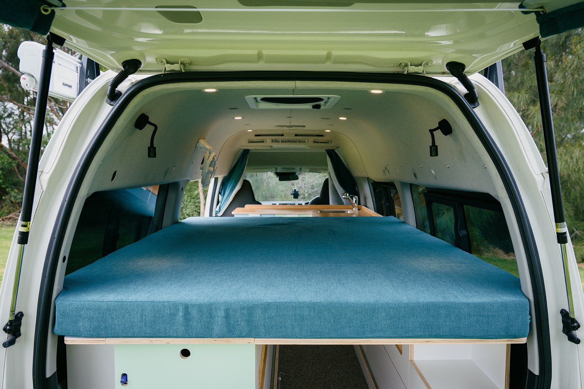blue mattress and cabinetry in Toyota Hiace Campervan conversion