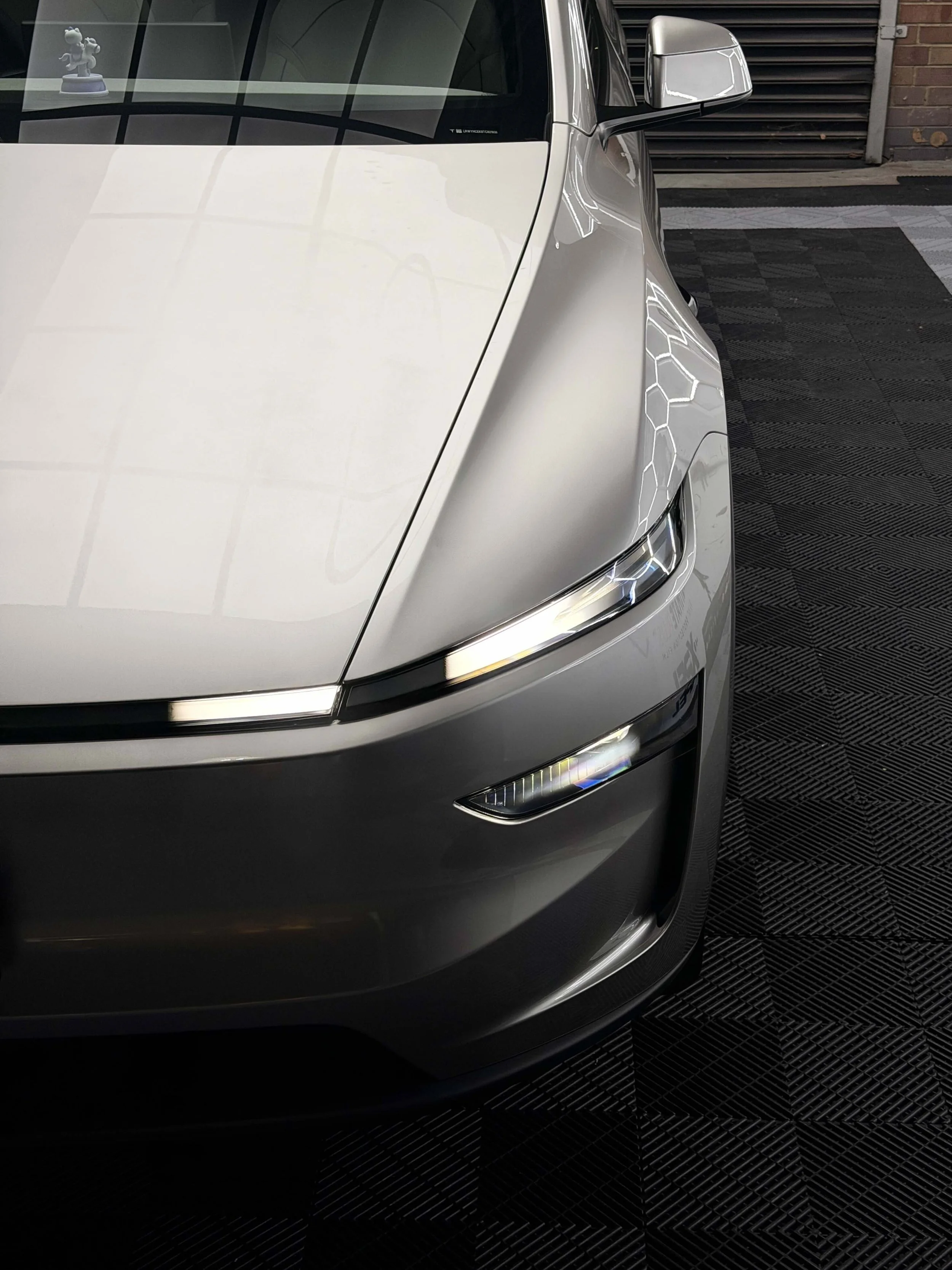 Tesla Model YL Ceramic coating and Paint Protection Film Package. Front on high angle 3/4 shot