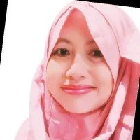 Person wearing a pink hijab, smiling at the camera.