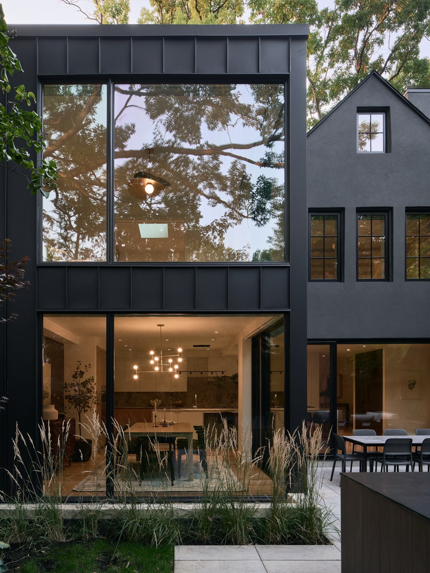 Love seeing the reflection of the trees in these beautiful large windows. Exterior view of a full home remodel + modern addition we completed with @steinregency | @steinbuild. Do you have a new build or larger scale renovation / addition planned, get