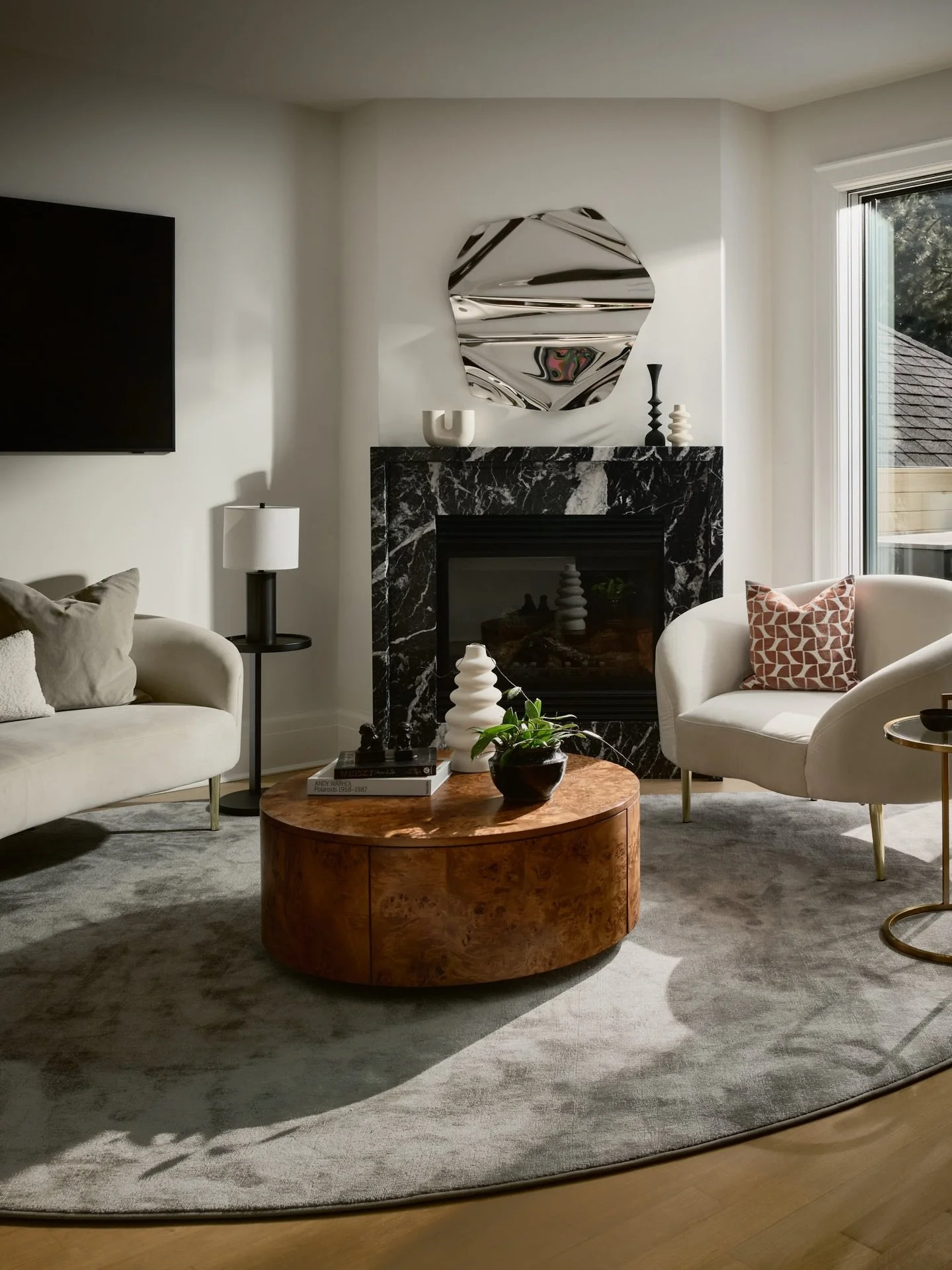 What do you do with a corner fireplace? It&rsquo;s always a tricky feature&mdash;beautiful, but it adds a whole new layer of complexity to furniture layout.

For this space, we leaned into it. We elevated the fireplace with a custom marble mantel, tu