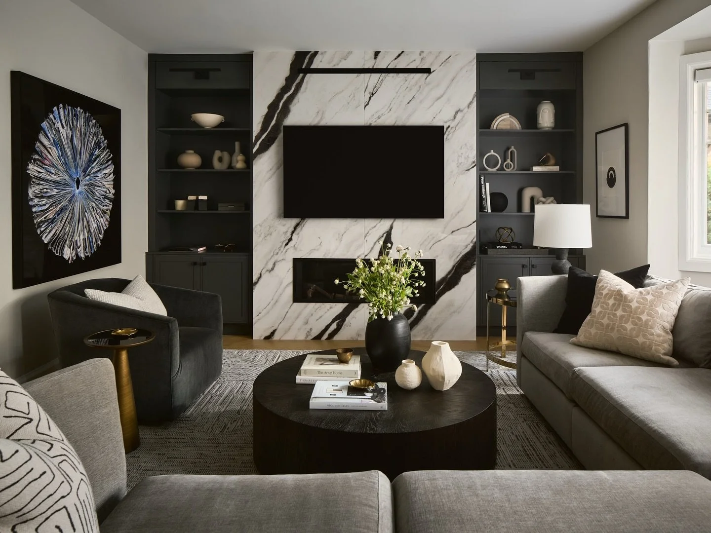 Transforming our clients living room to provide more storage and seating while still accommodating tv viewing and a fireplace. Many asks and it required smart space planning, custom millwork and proper scale of furniture. 

Photo: @morley2space | @2s