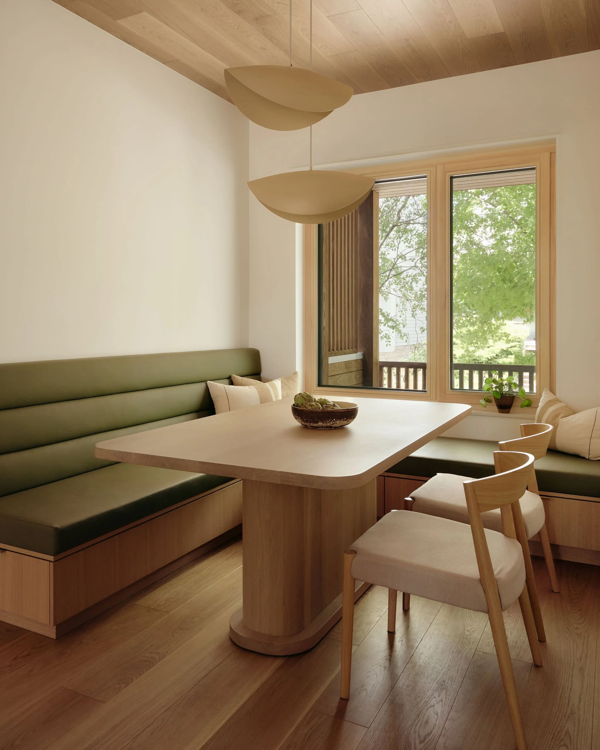 03 prefab-passive-house banquette builtin storage wood ceiling.jpeg