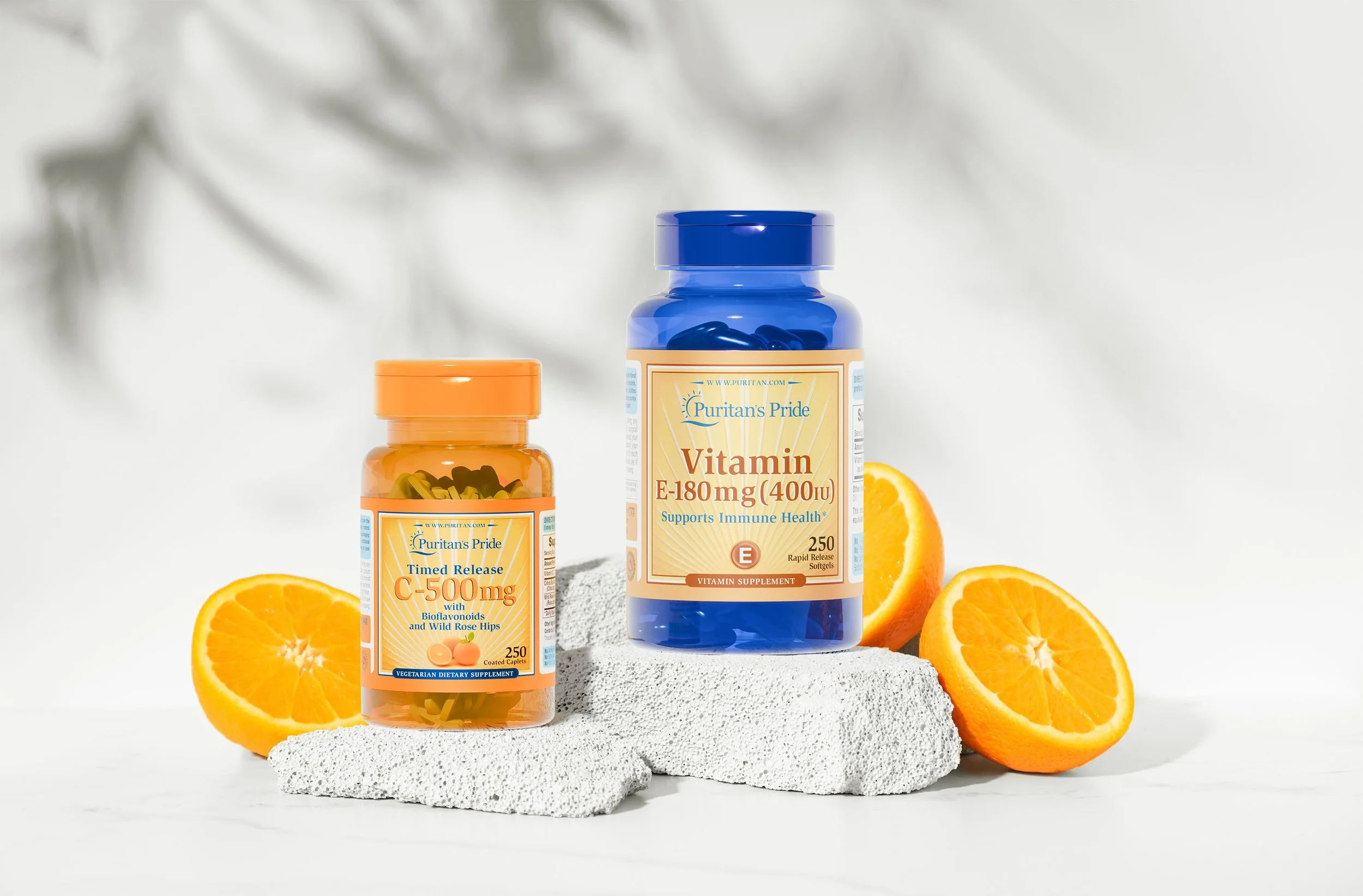 Vitamin supplement bottles labeled Puritan's Pride with oranges and white textured stones.