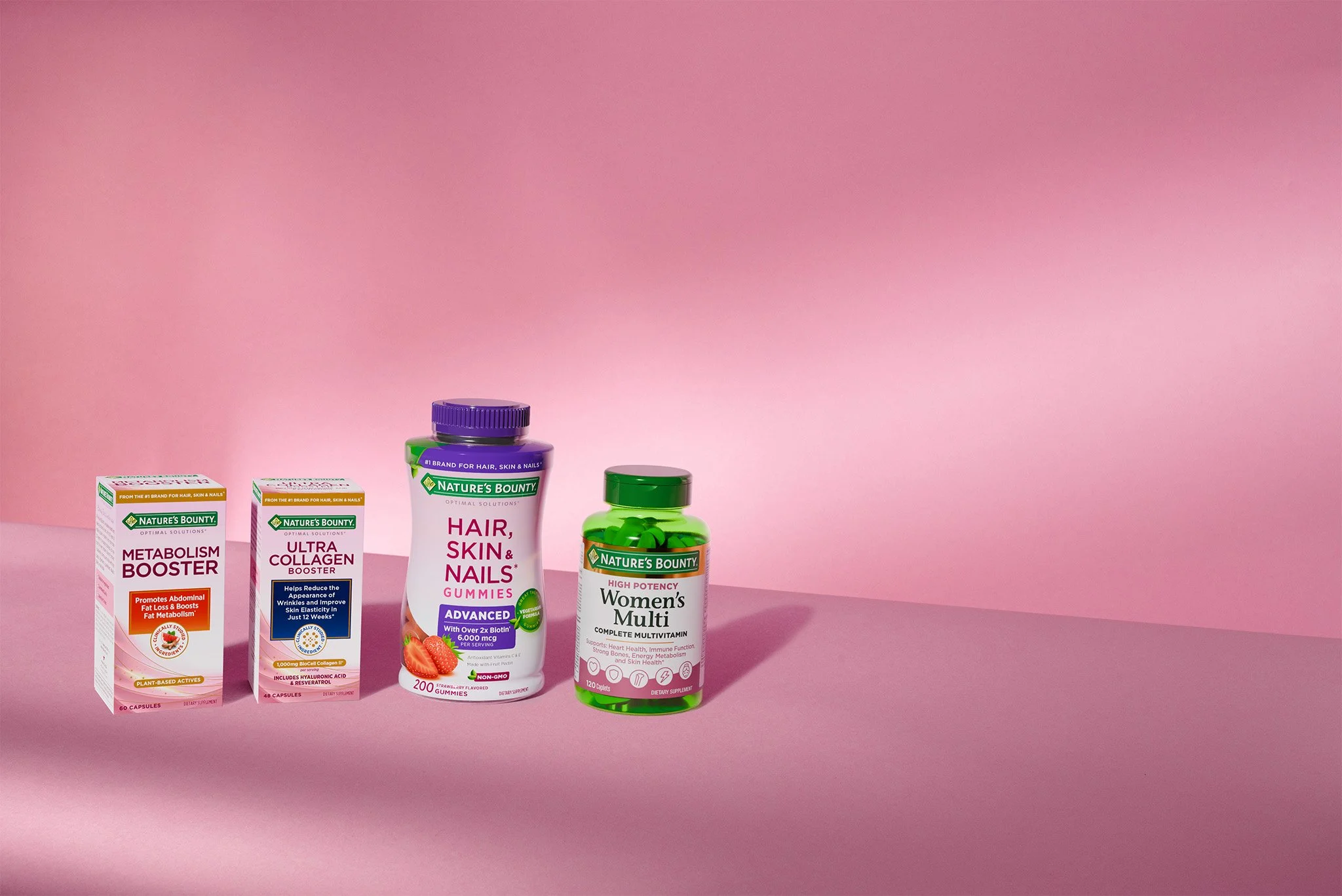 Supplements and vitamins from Nature's Bounty on a pink background, including metabolism booster, ultra collagen, hair, skin, and nails gummies, and women’s multi