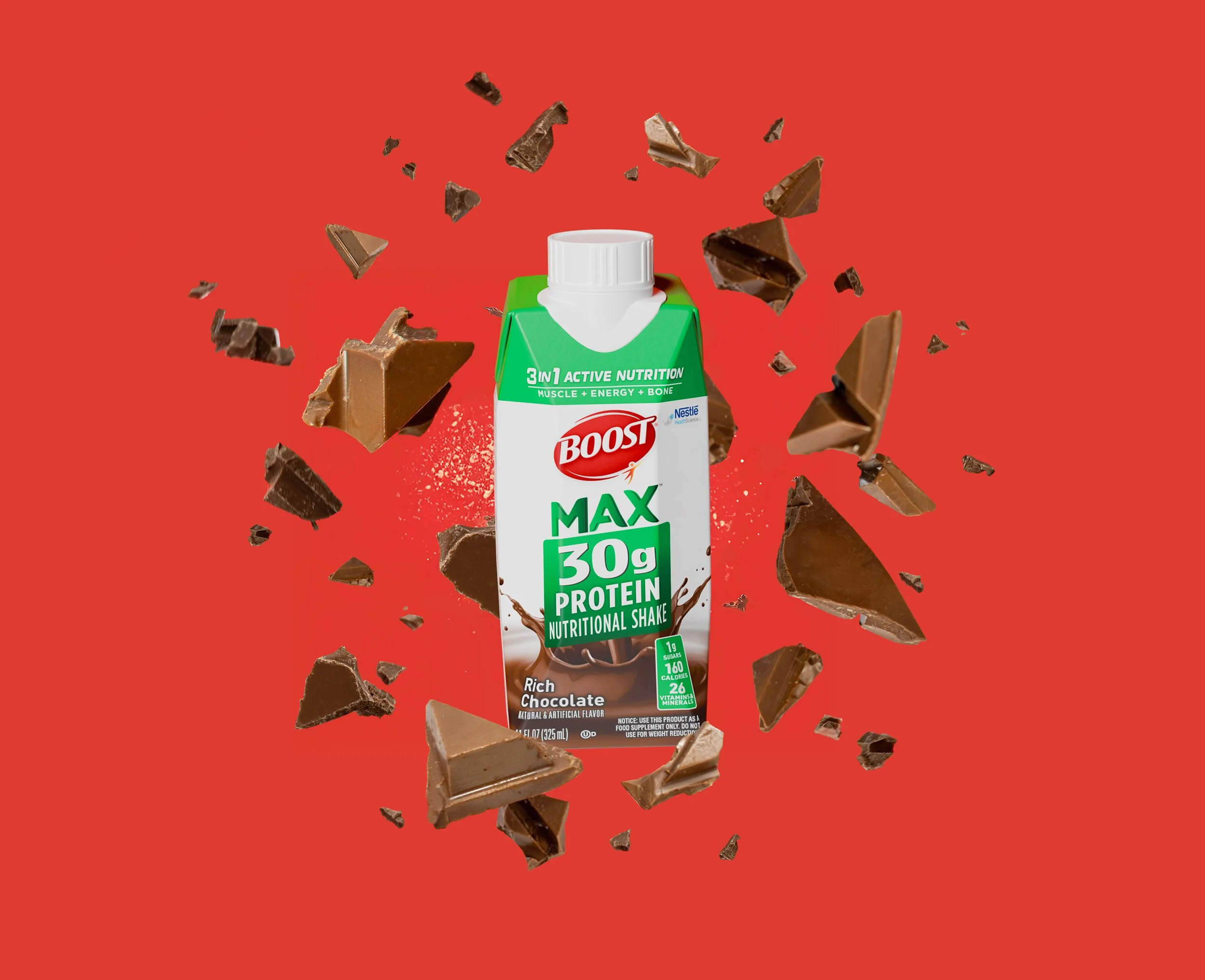 A Boost Max Protein nutritional shake carton with chocolate flavor surrounded by broken pieces of chocolate flying around against a red background.