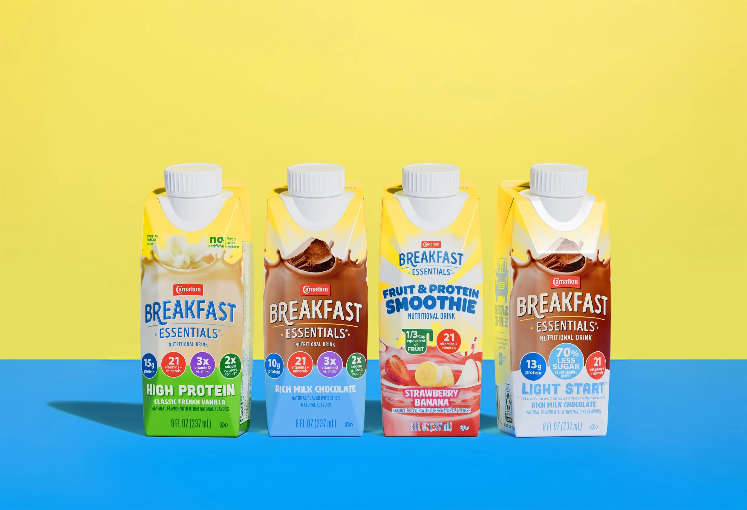 Four cartons of breakfast drink beverages arranged on a colorful background, including flavors like vanilla, chocolate, strawberry banana, and rich milk chocolate.