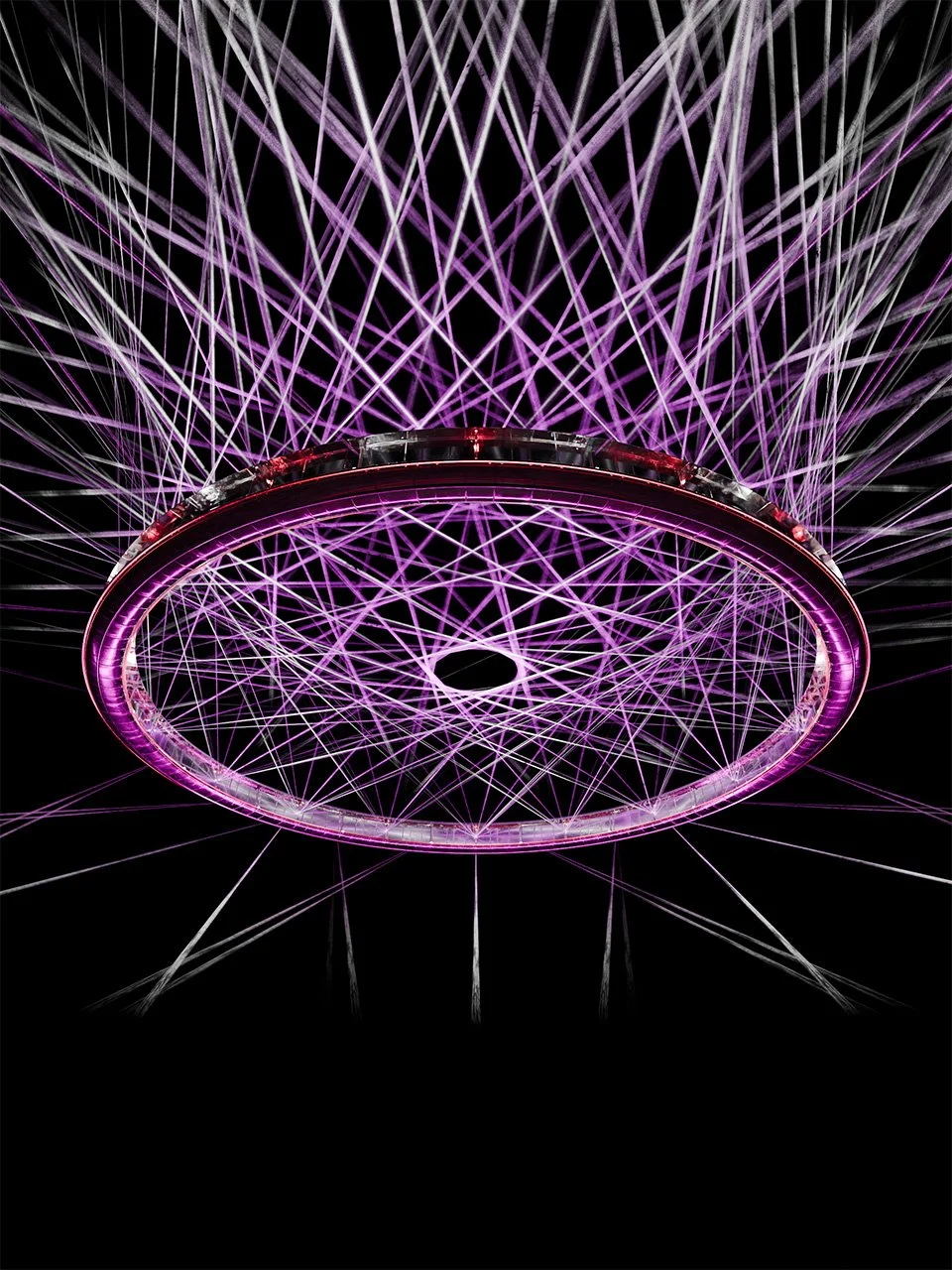 Large glowing purple ring with hundreds of intersecting light beams against a black background