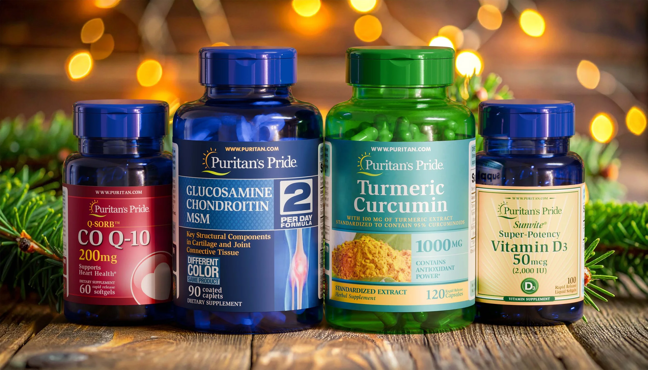 Four supplement bottles on a wooden surface with Christmas greenery and blurred warm lights in the background. From left to right: a black bottle of CO Q-10, a blue bottle of Glucosamine Chondroitin MSM, a green bottle of Turmeric Curcumin, and a blue bottle of Super-Potency Vitamin D3.