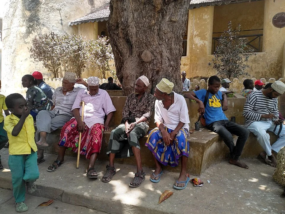 Elderly men sitting and talking at Mkunguni Square in Lamu Old Town, Kenya