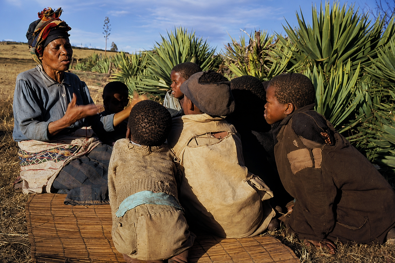 African elder sharing stories and proverbs with children during a traditional storytelling session.