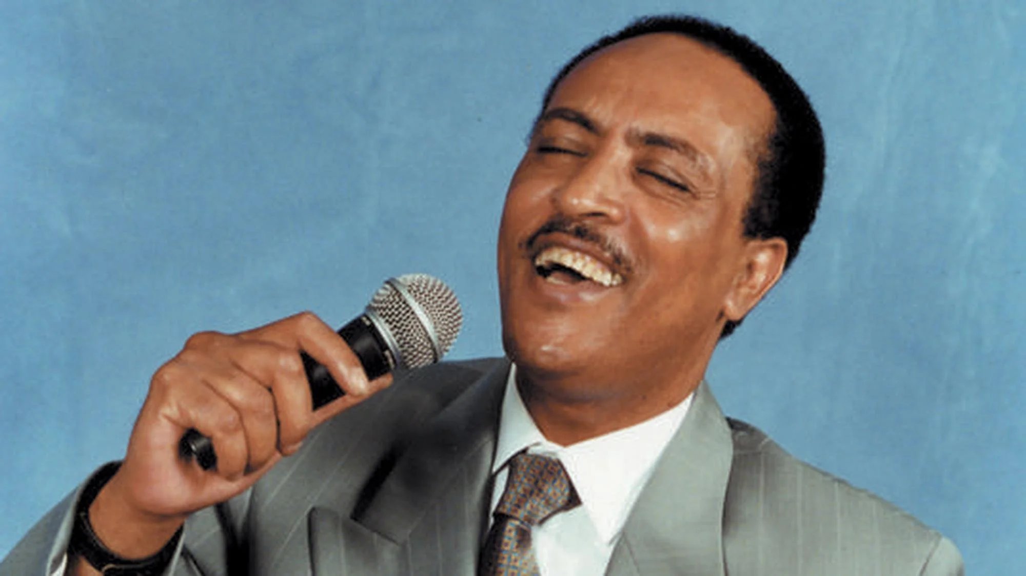 Ethiopian singer Tilahun Gessesse performing with a microphone during the Golden Age of Ethiopian music