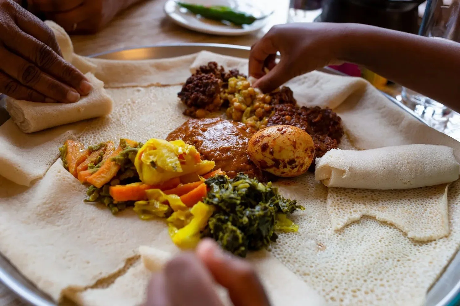 Traditional Ethiopian stews and vegetables served together on injera for communal dining