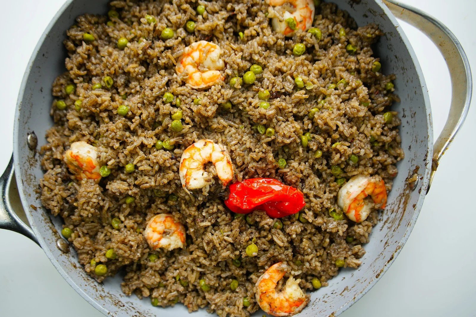 Haitian diri djon djon served with shrimp, green peas, and Scotch bonnet pepper.