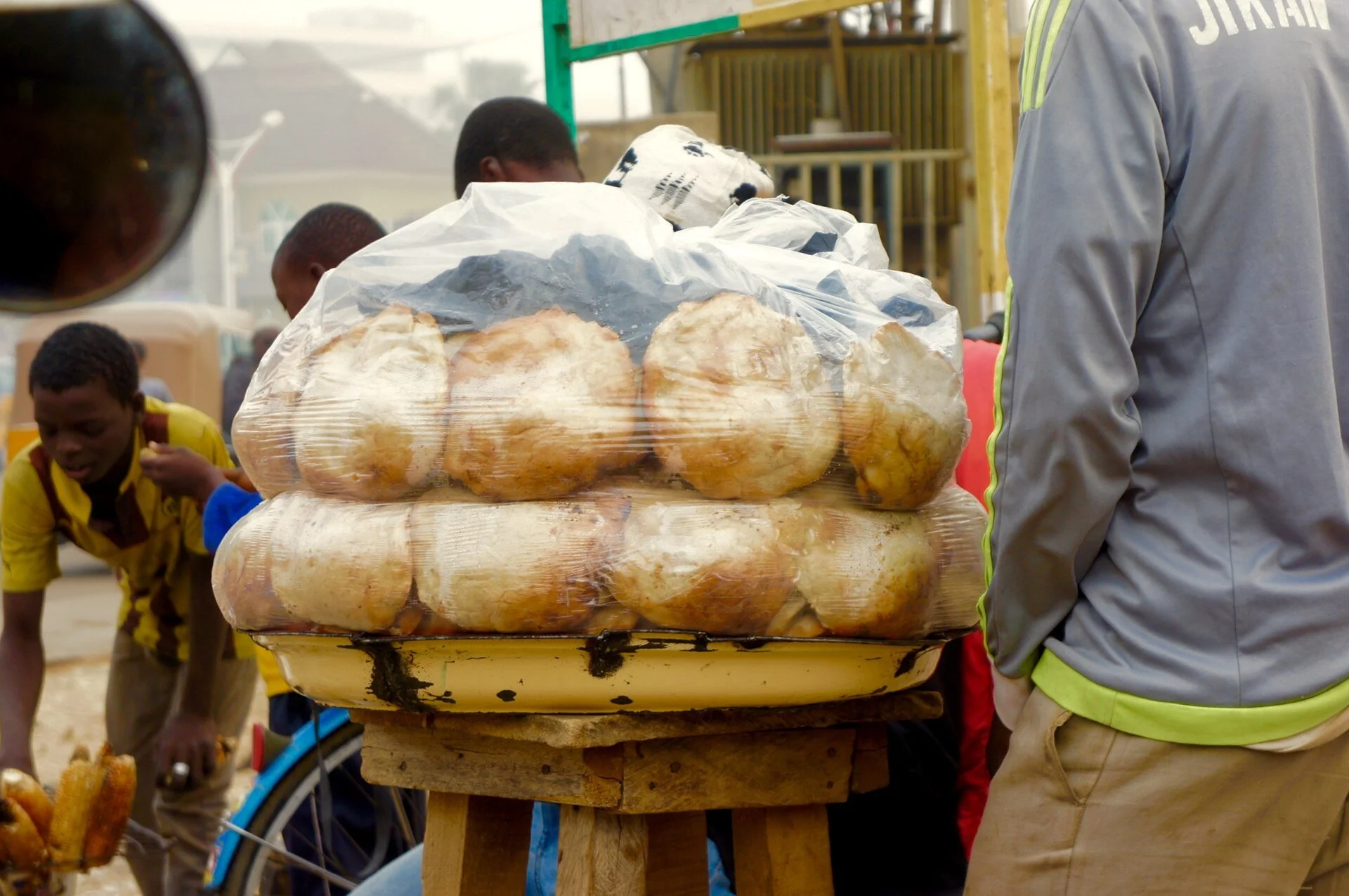 Bags of round gurasa bread stacked at a roadside food stand