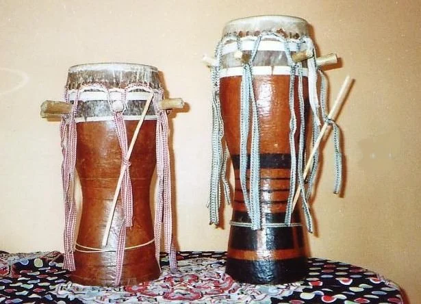 Two carved wooden Senegalese sabar drums standing side by side