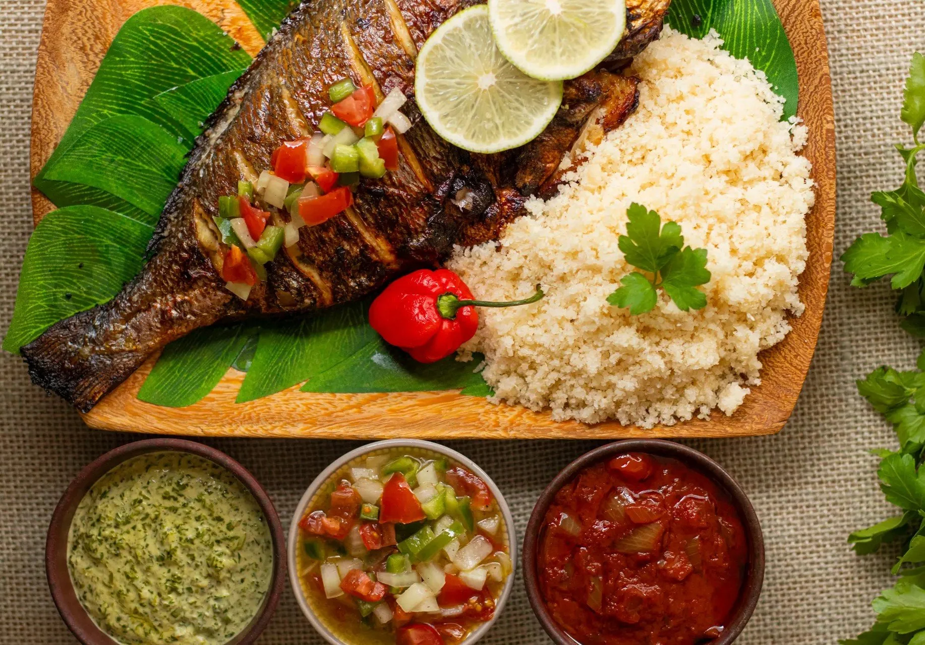 Traditional Ivorian attiéké served with grilled fish and moyo sauce.