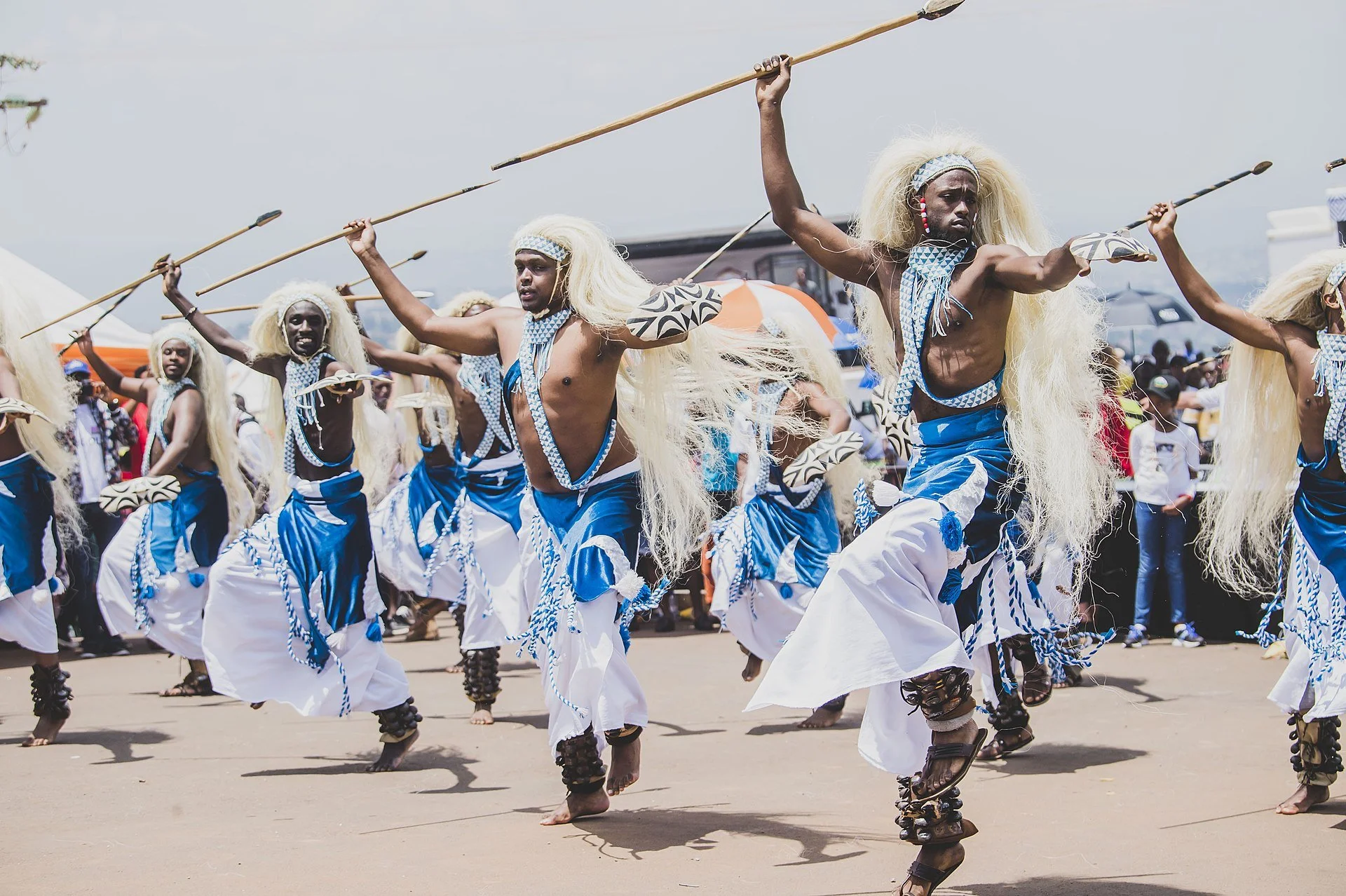 Rwandan Intore performers in traditional clothing carrying shields and spears