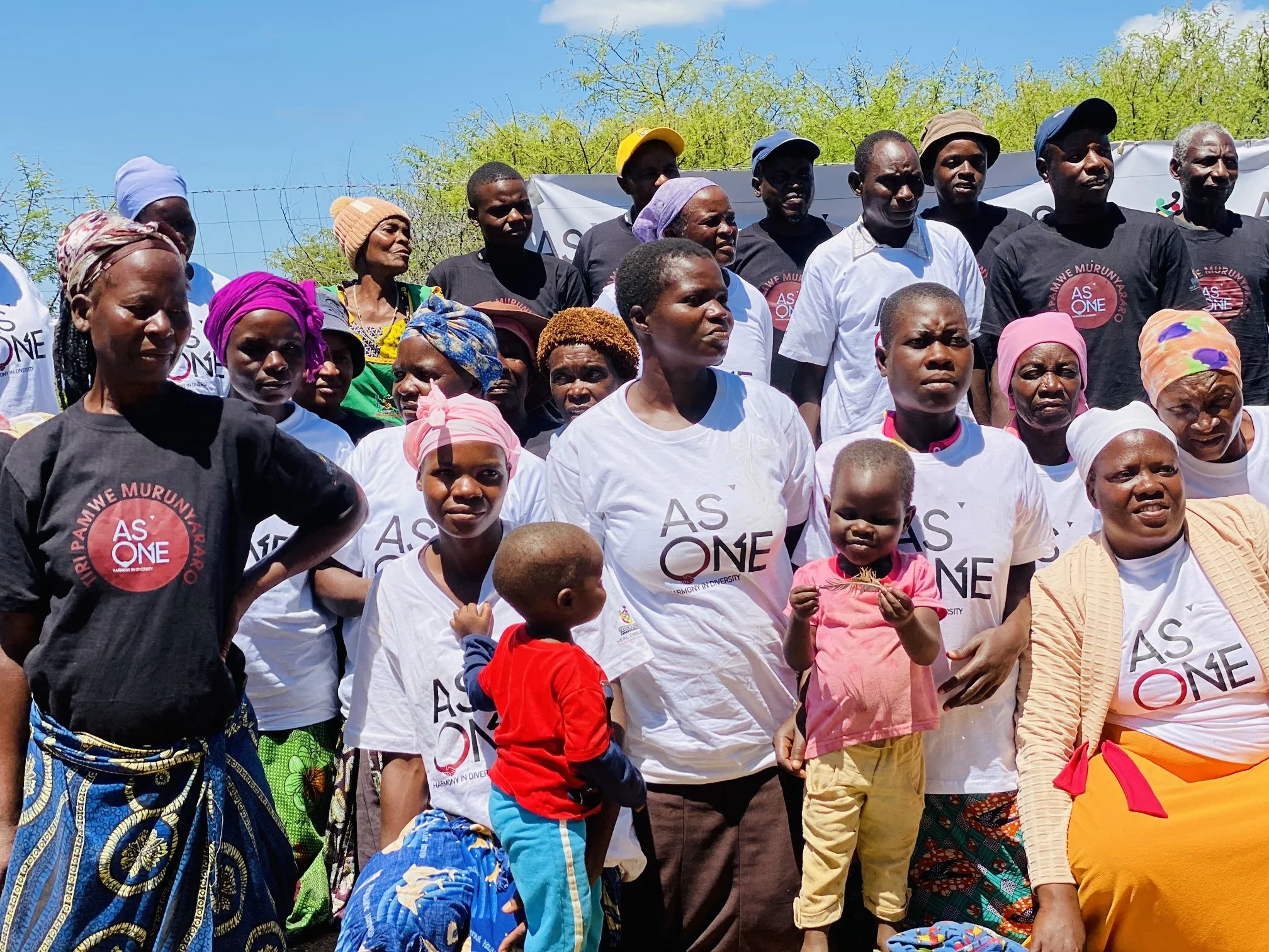 Kutatarika Peace Club members gathered outdoors in Zaka, with several wearing As One shirts