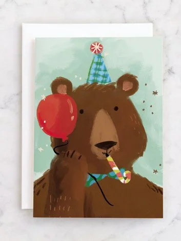 A fun illustration of a bear wearing a birthday hat, holding a red balloon, and a party blowout in its mouth, with small stars around.