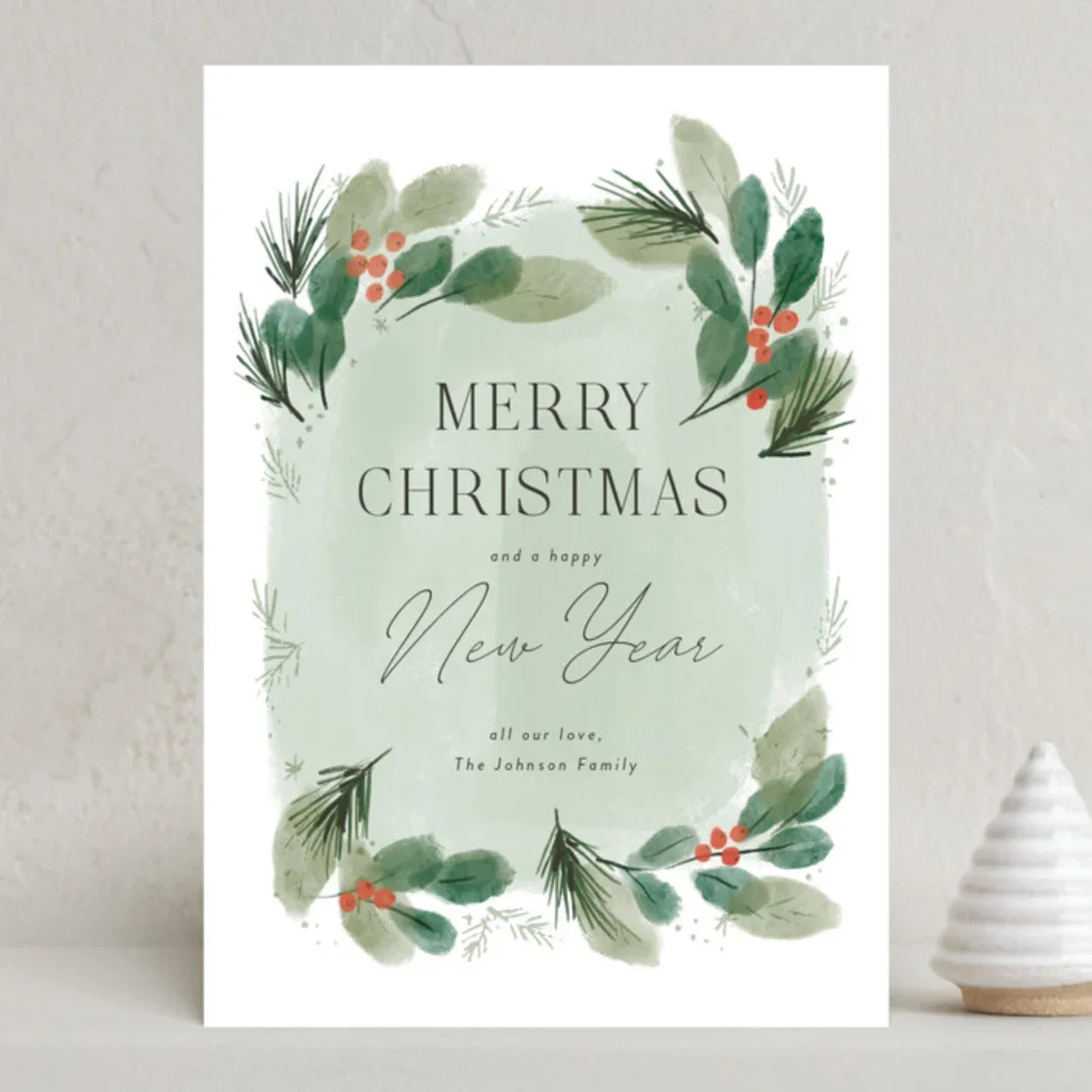 Christmas greeting card with green foliage and red berries, reading "Merry Christmas and a happy New Year".